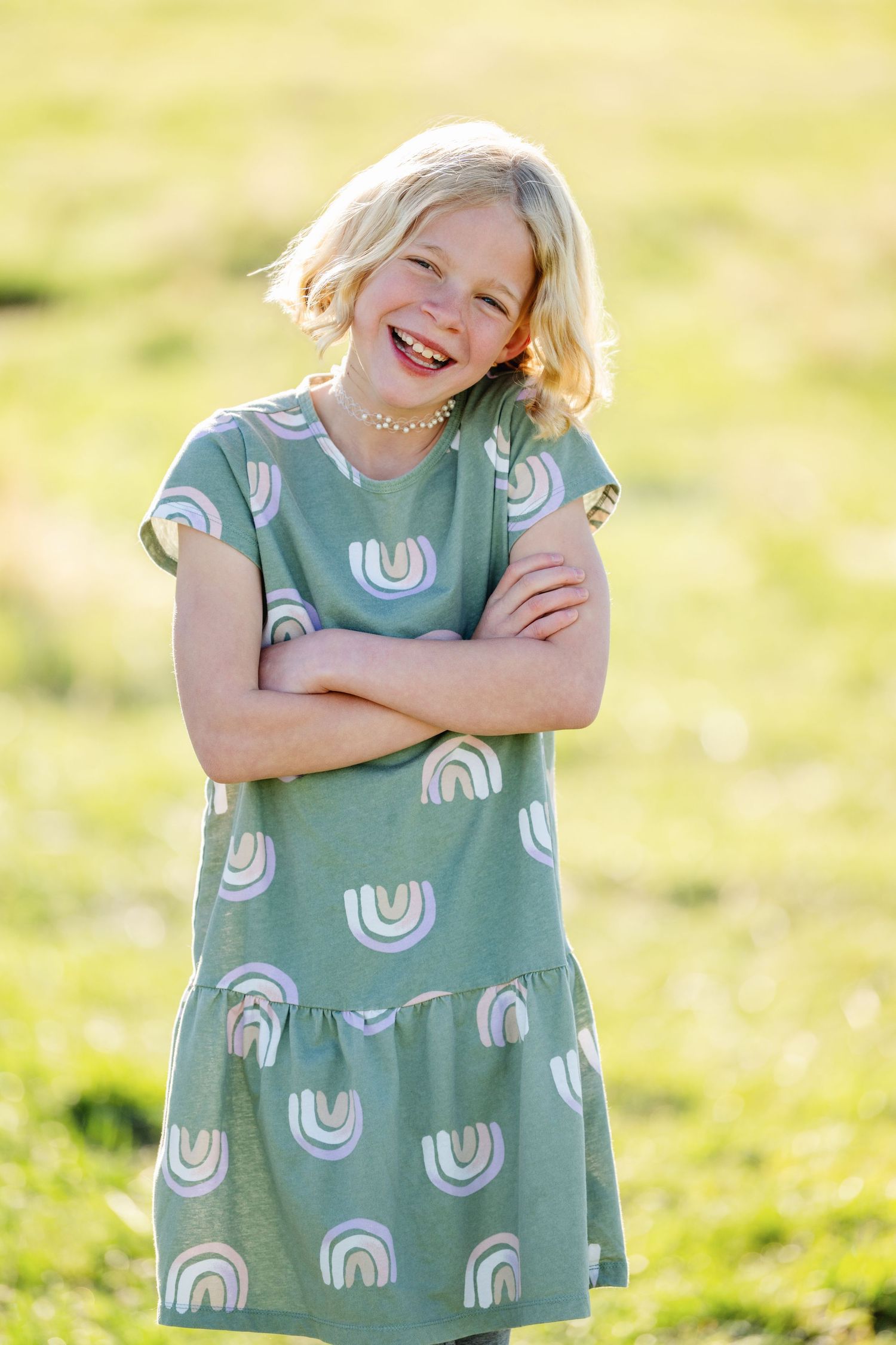 Young girl smiling in grassy field during outdoor family photography session