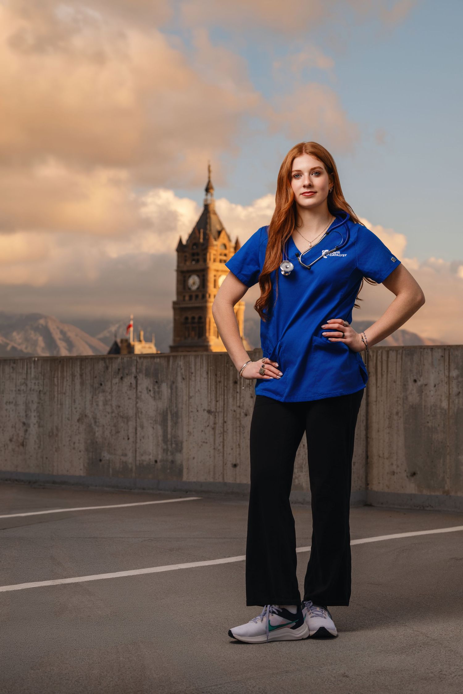 Senior girl portrait on rooftop in Salt Lake City with sunset sky and confident pose in modern urban setting