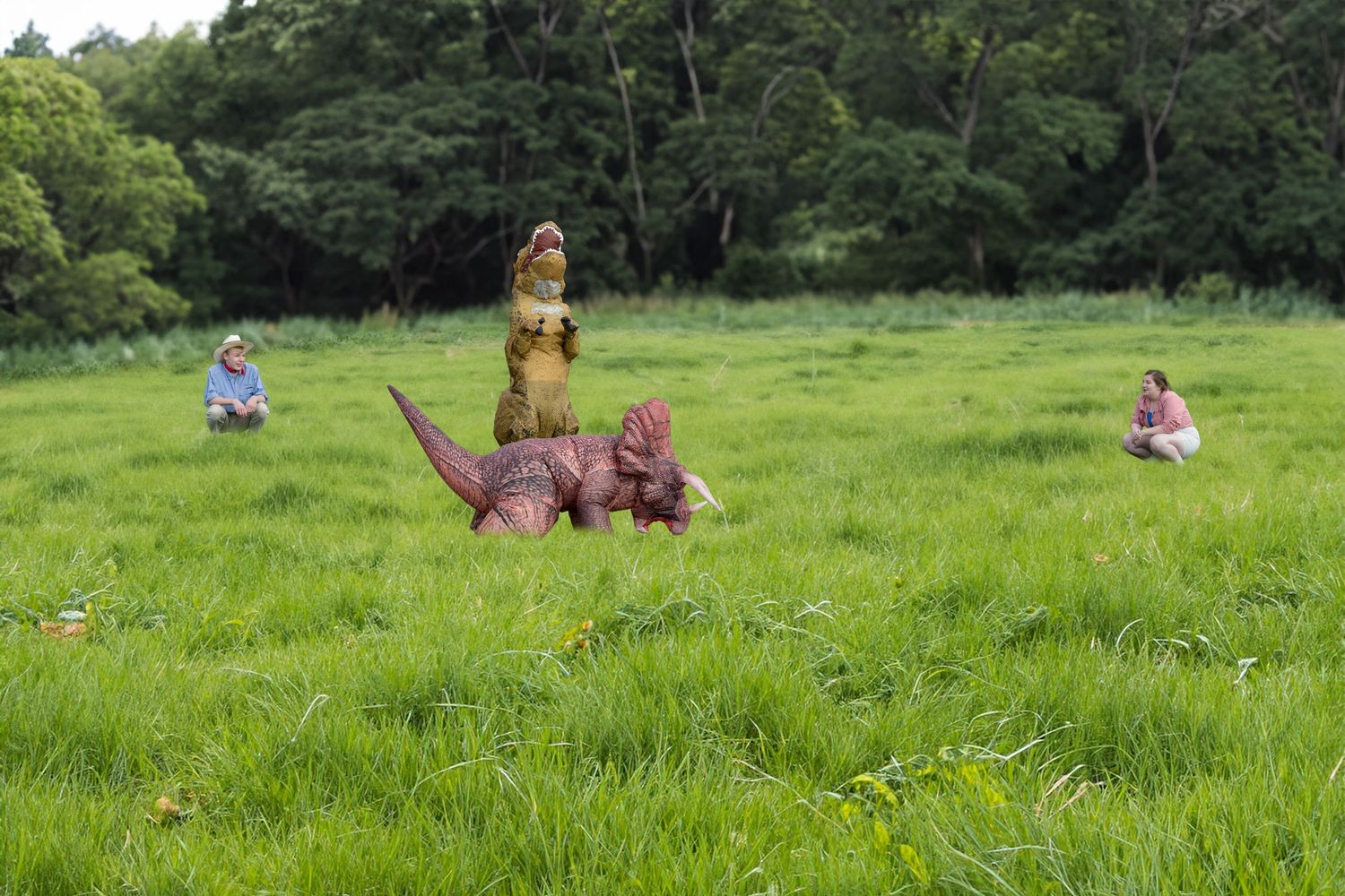 Teens posing in field with inflatable dinosaur costume in playful themed photo