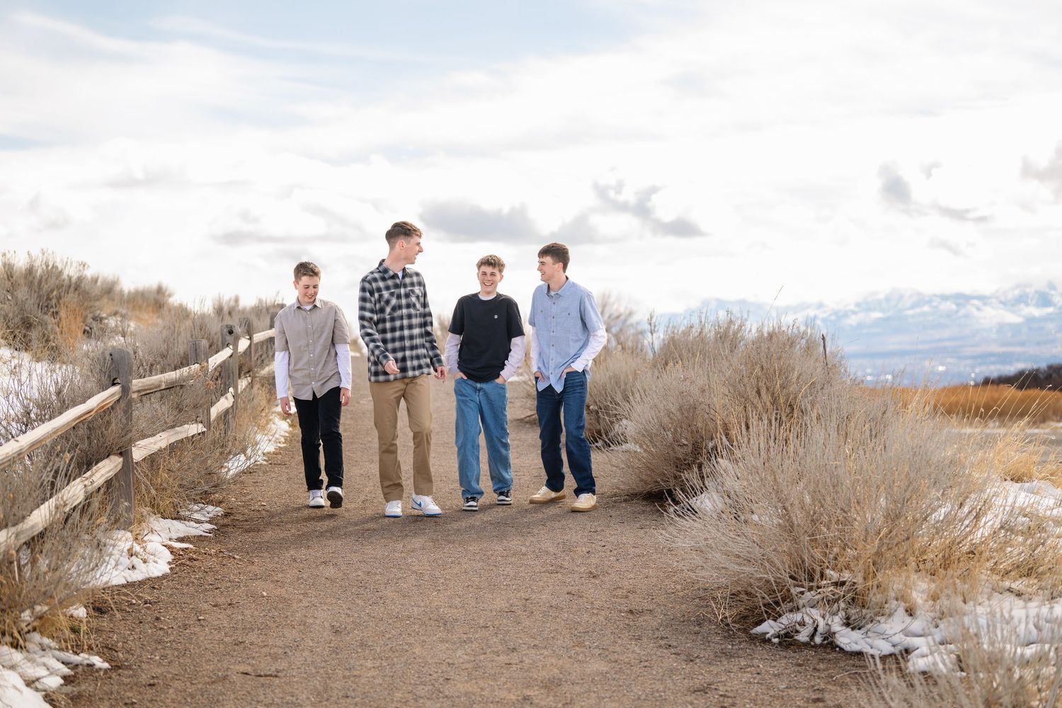 Group portrait of teenage boys walking along outdoor trail with mountain landscape background