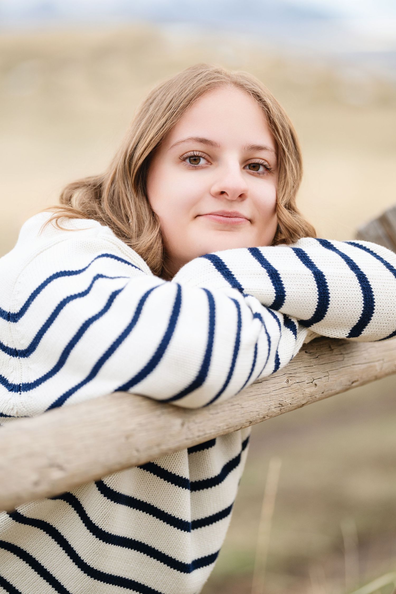 Close up senior girl portrait leaning on wooden fence during outdoor Utah senior photography session