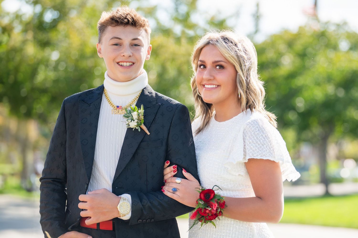 Bountiful High Homecoming couple smiling together outdoors in formal attire with soft greenery