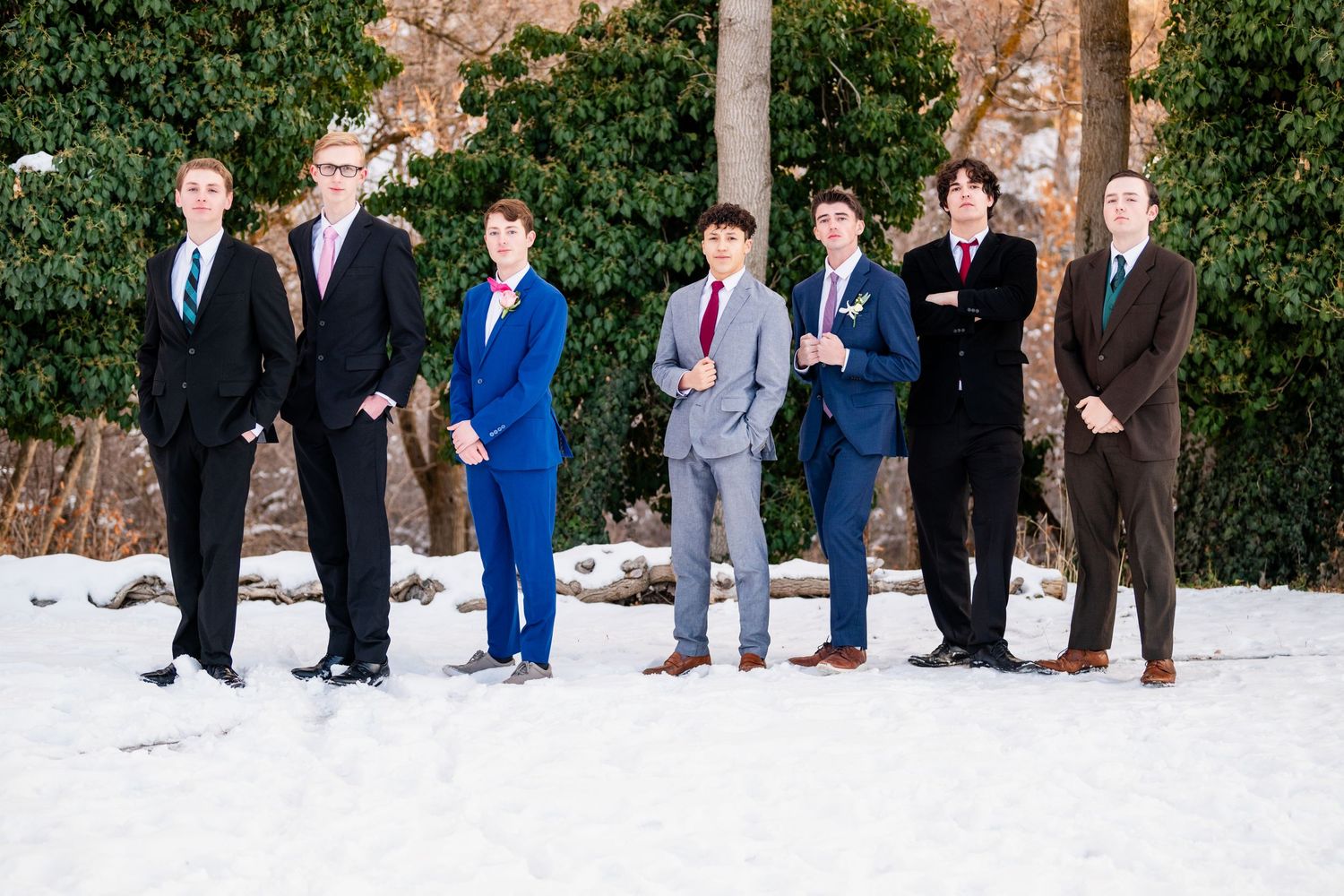 Group of boys in suits posing outdoors in snow with formal and casual mix