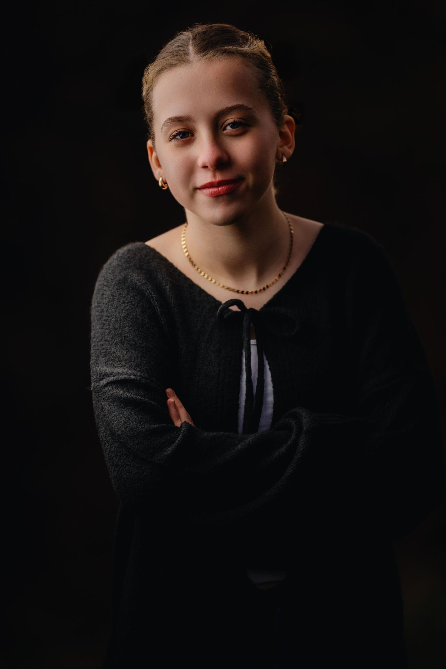 Outdoor studio lit portrait of teen girl in black outfit with soft directional lighting and confident pose