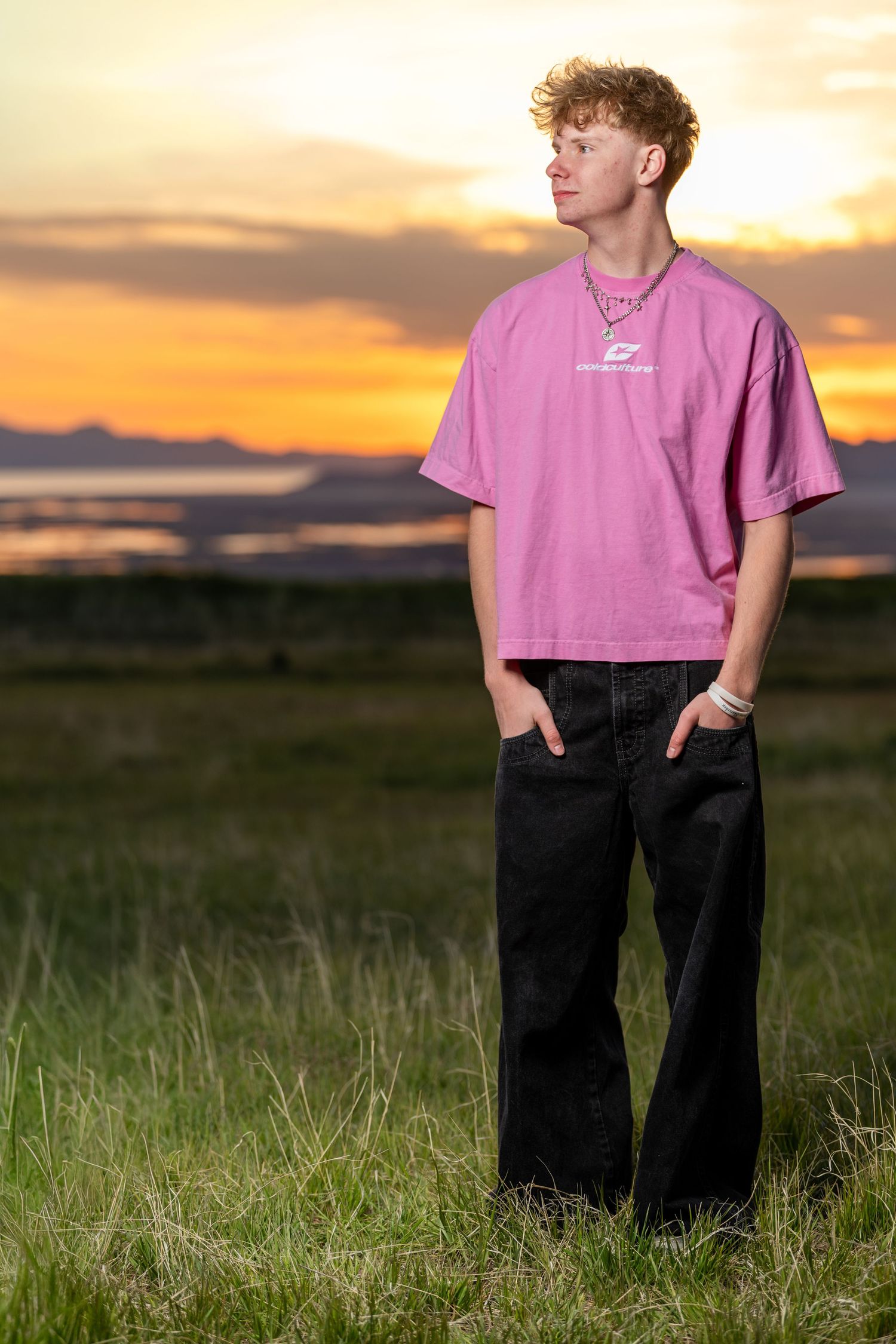 Class of 2026 senior portrait in Utah field at sunset with casual streetwear style