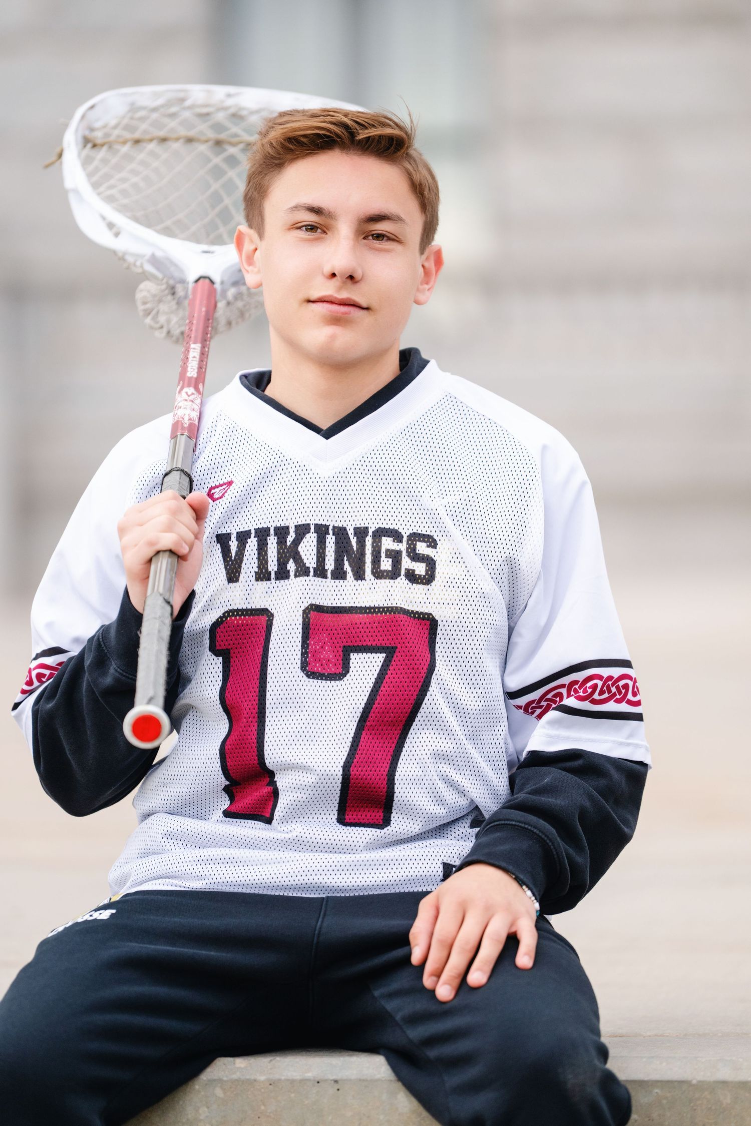 Viewpoint High school lacrosse player portrait holding lacrosse stick during varsity senior sports photography session