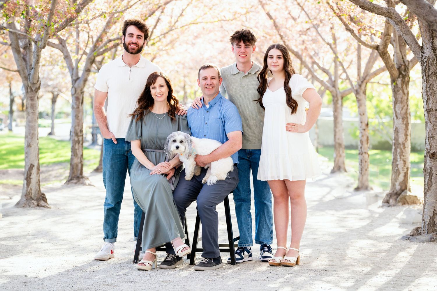 Family portrait in Utah State Capitol tree-lined path with soft light and natural posing and neutral tones