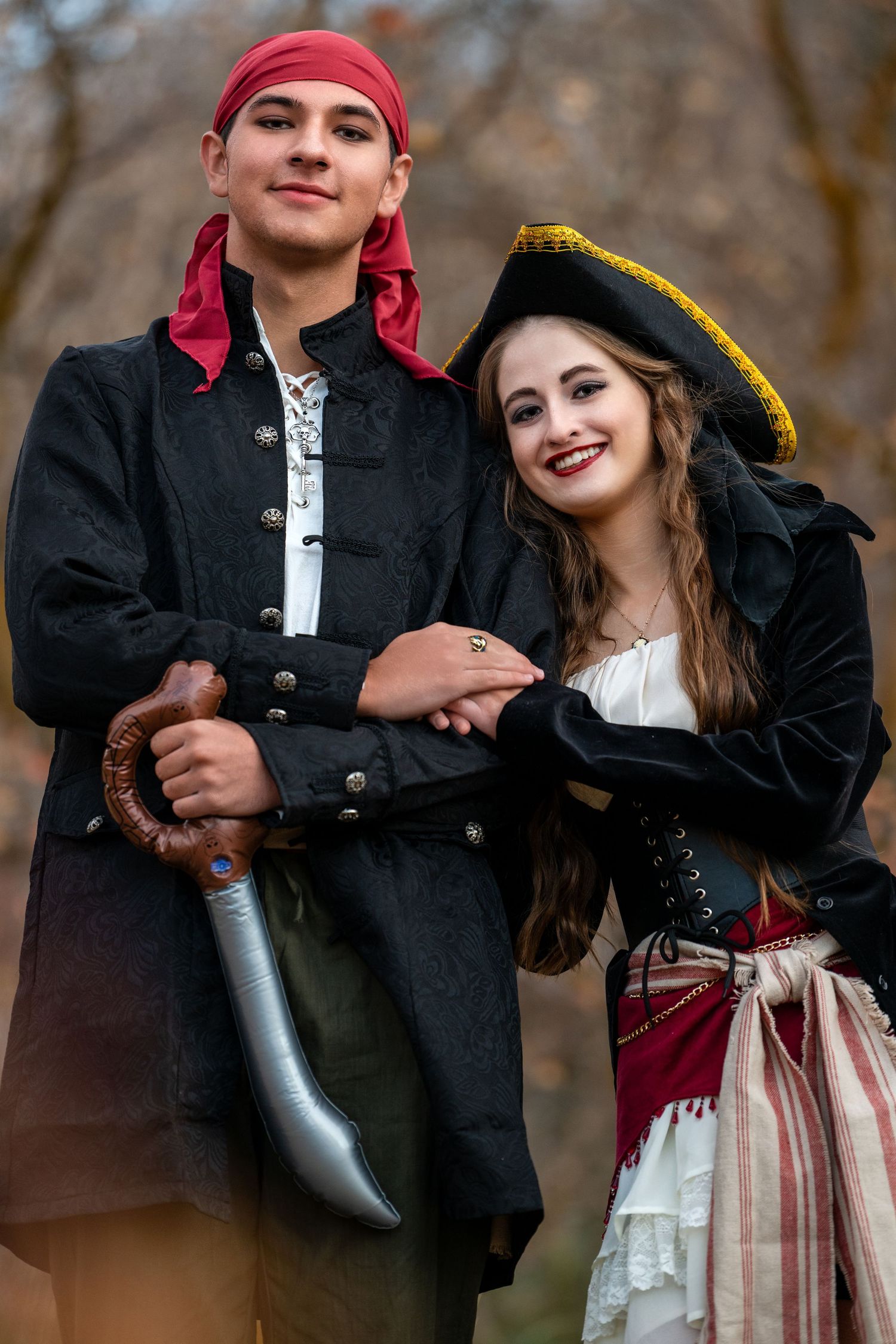 Couple dressed as pirates posing together for the Sadie Hawkins dance with playful expressions outdoors