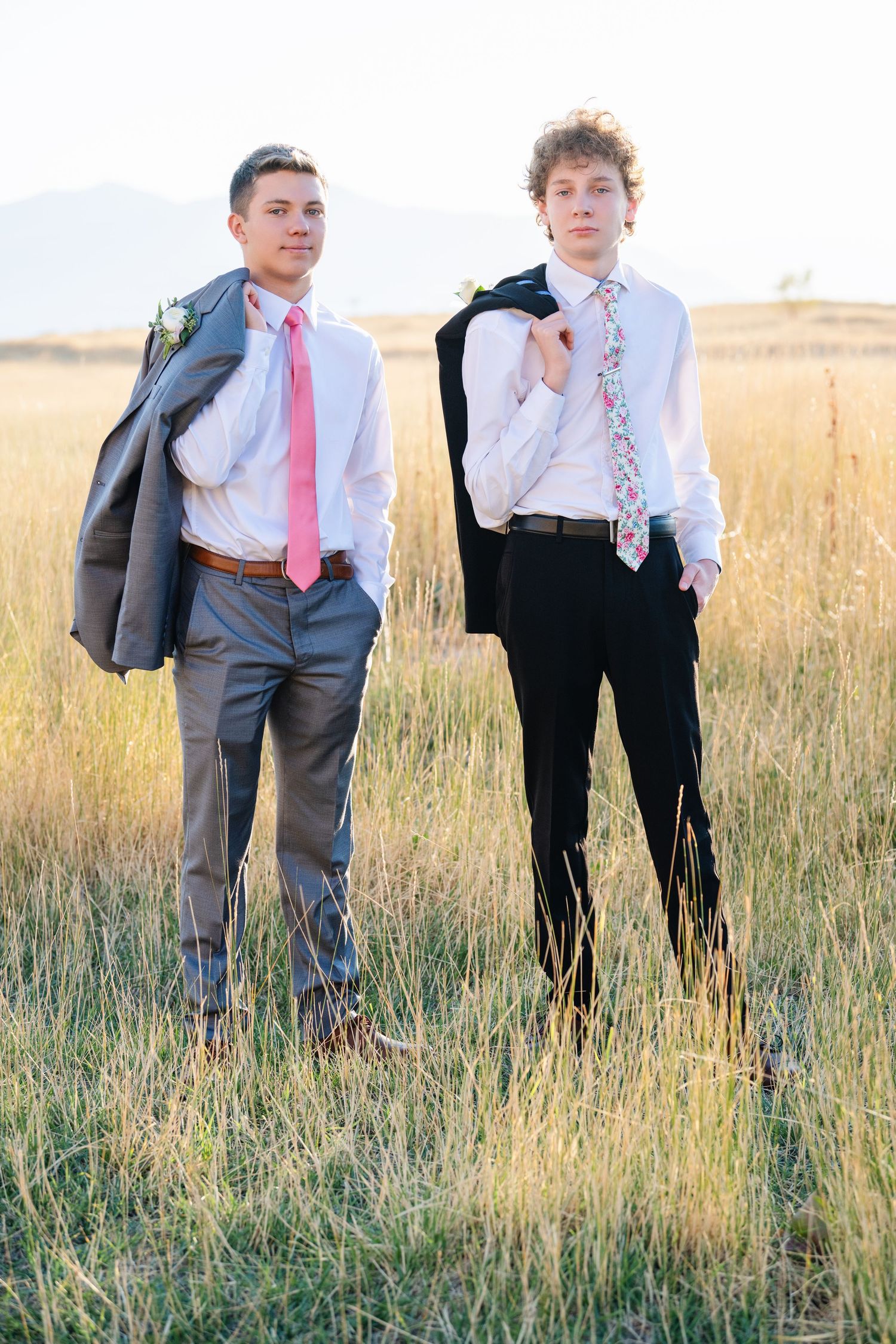 Two boys standing in field in dress shirts and ties with casual confident pose