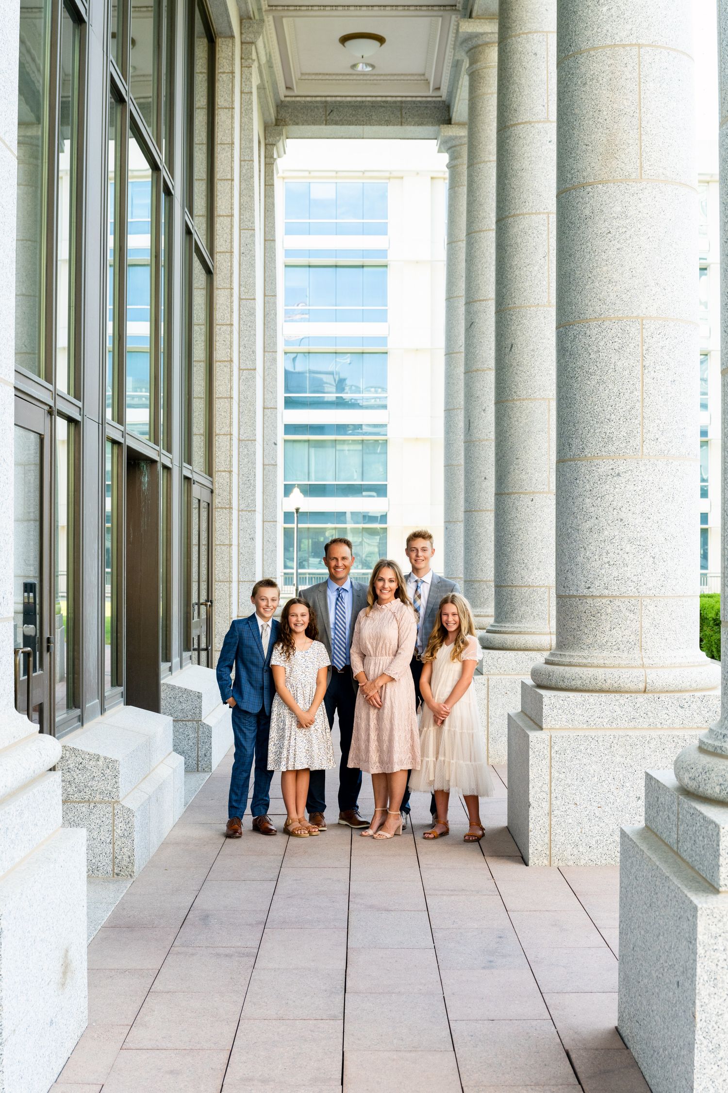 Family portrait in Salt Lake City state capitol with white columns and bright natural light and clean composition