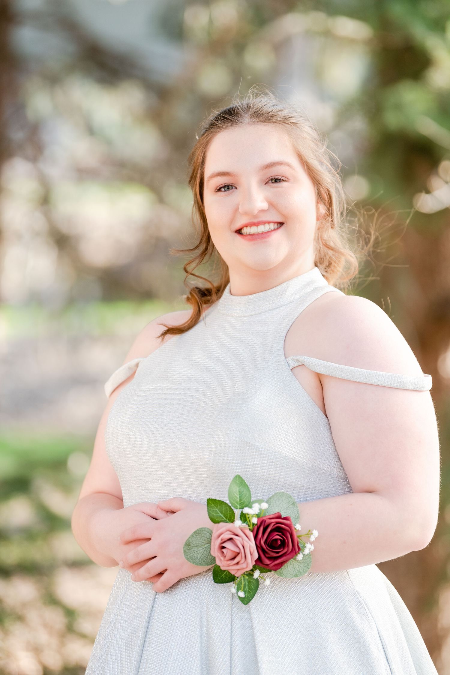 Senior girl portrait wearing corsage in light blue dress with soft natural light