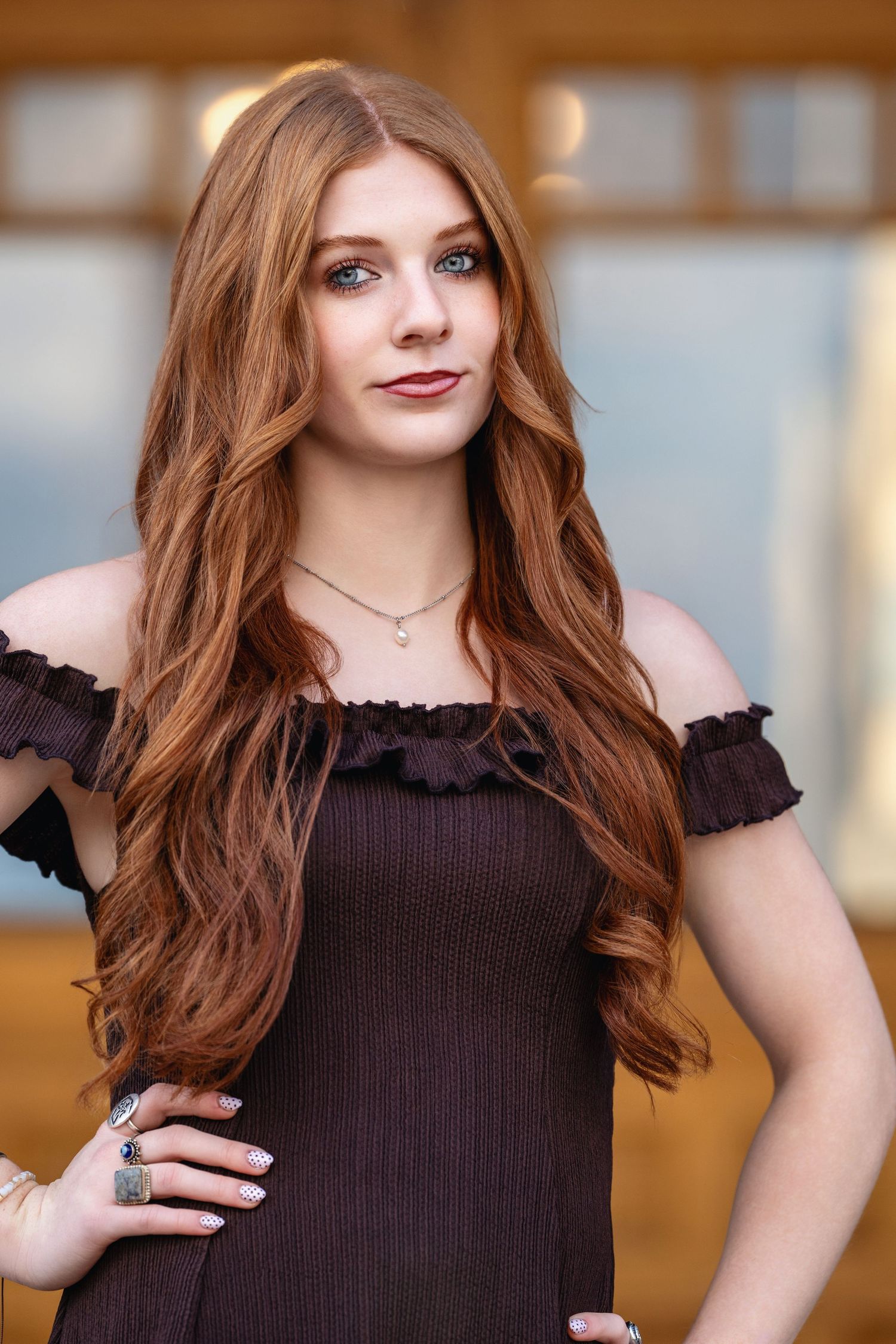 Senior girl portrait in dark brown dress with soft natural light and warm tones in outdoor setting