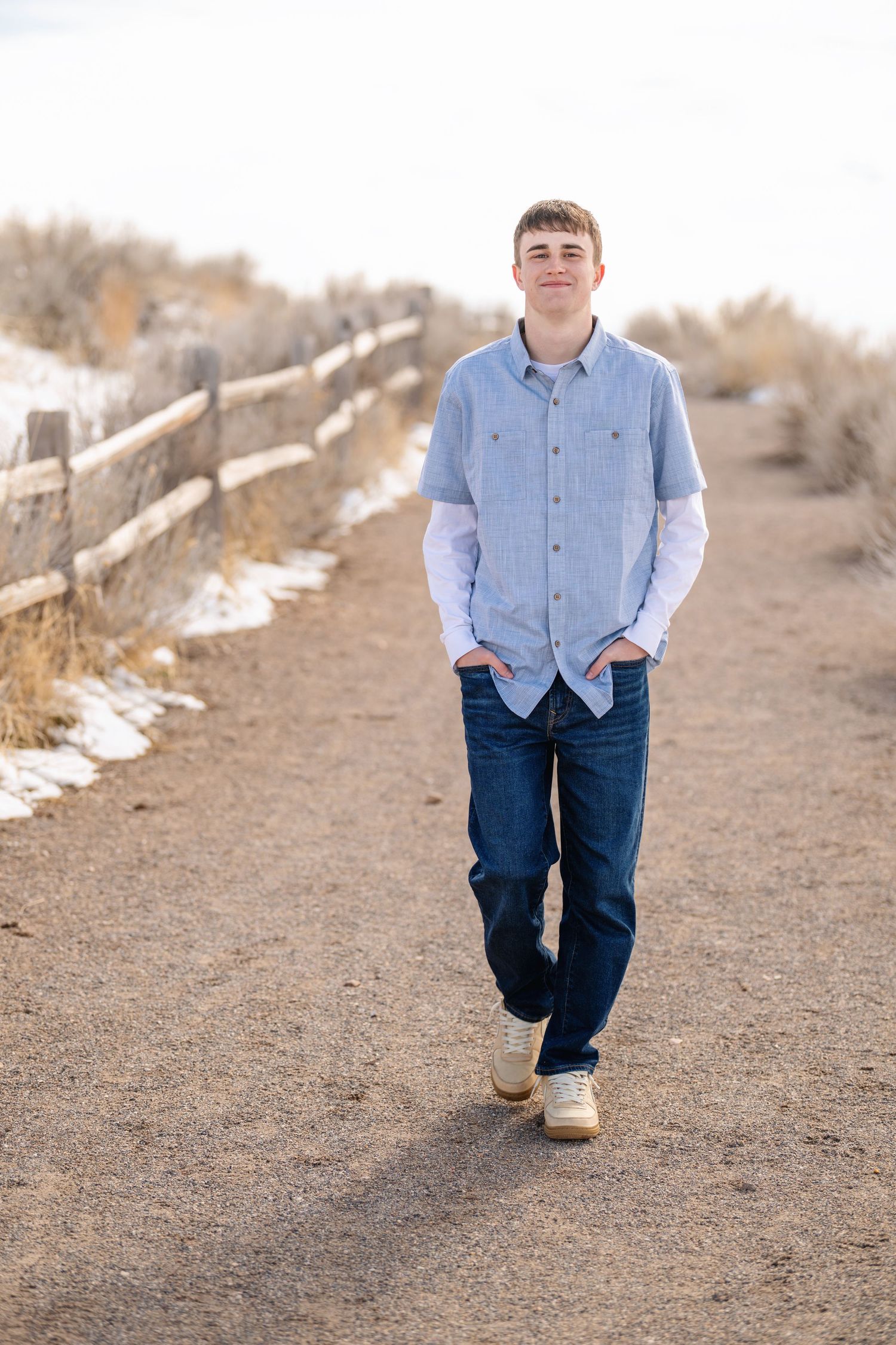 Teenage boy walking along rustic trail during outdoor family portrait session