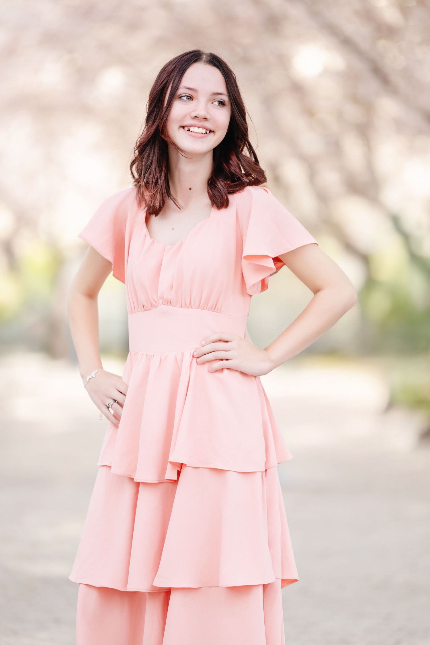 Smiling young girl portrait in pink dress during outdoor spring family photography session
