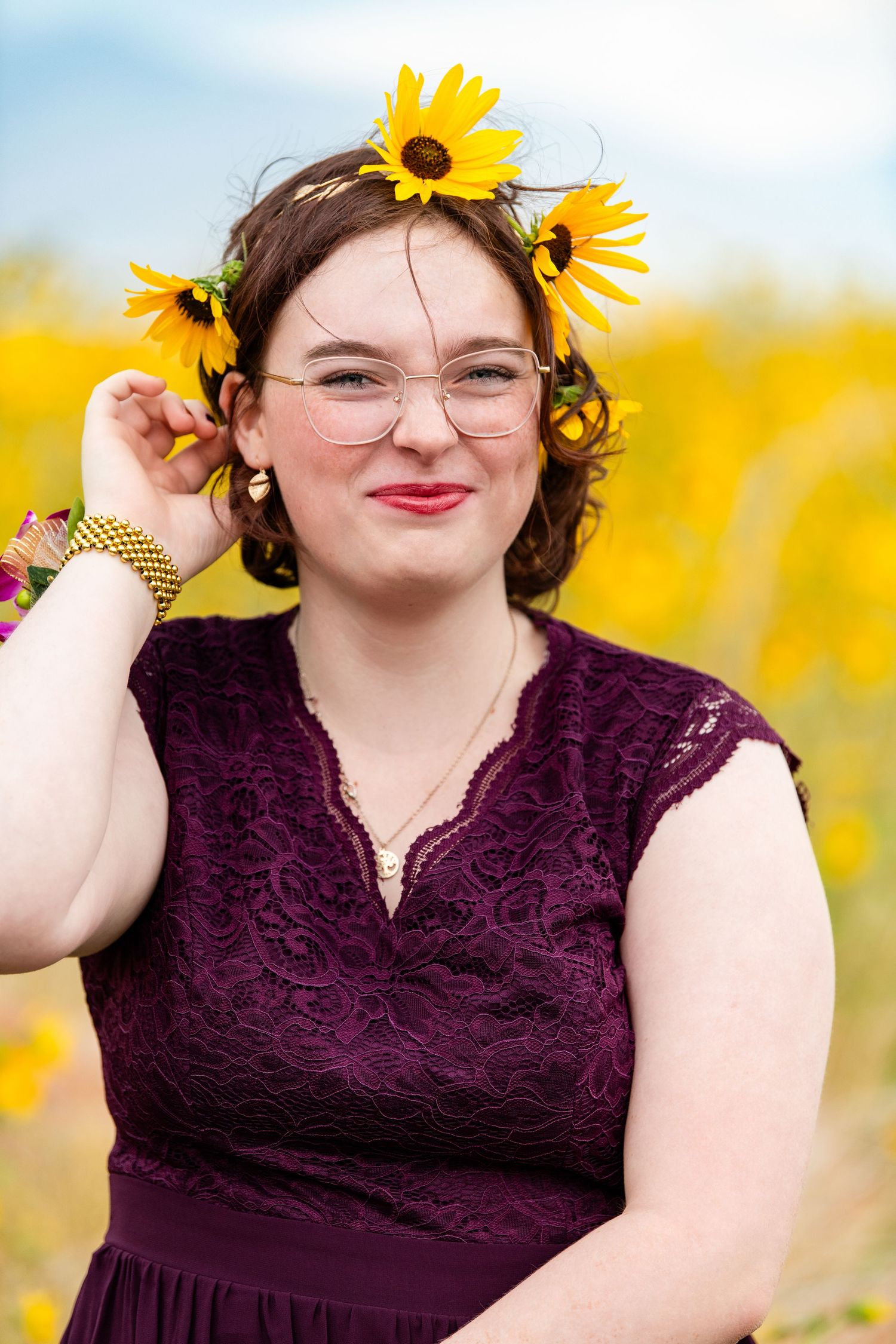 Senior girl portrait wearing sunflower crown in yellow field with warm tones