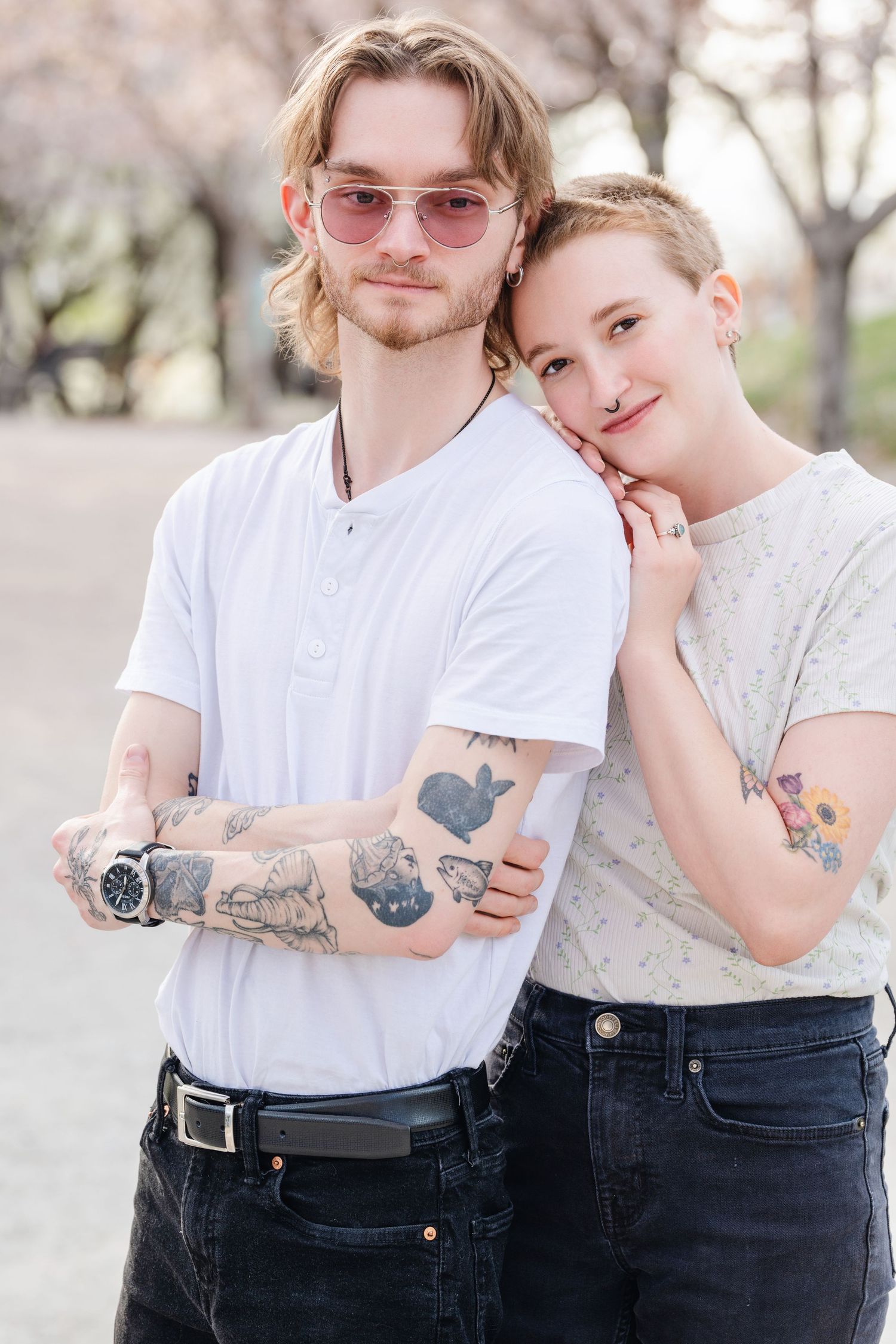 Young couple portrait with tattoos and casual white outfits during outdoor spring photography session