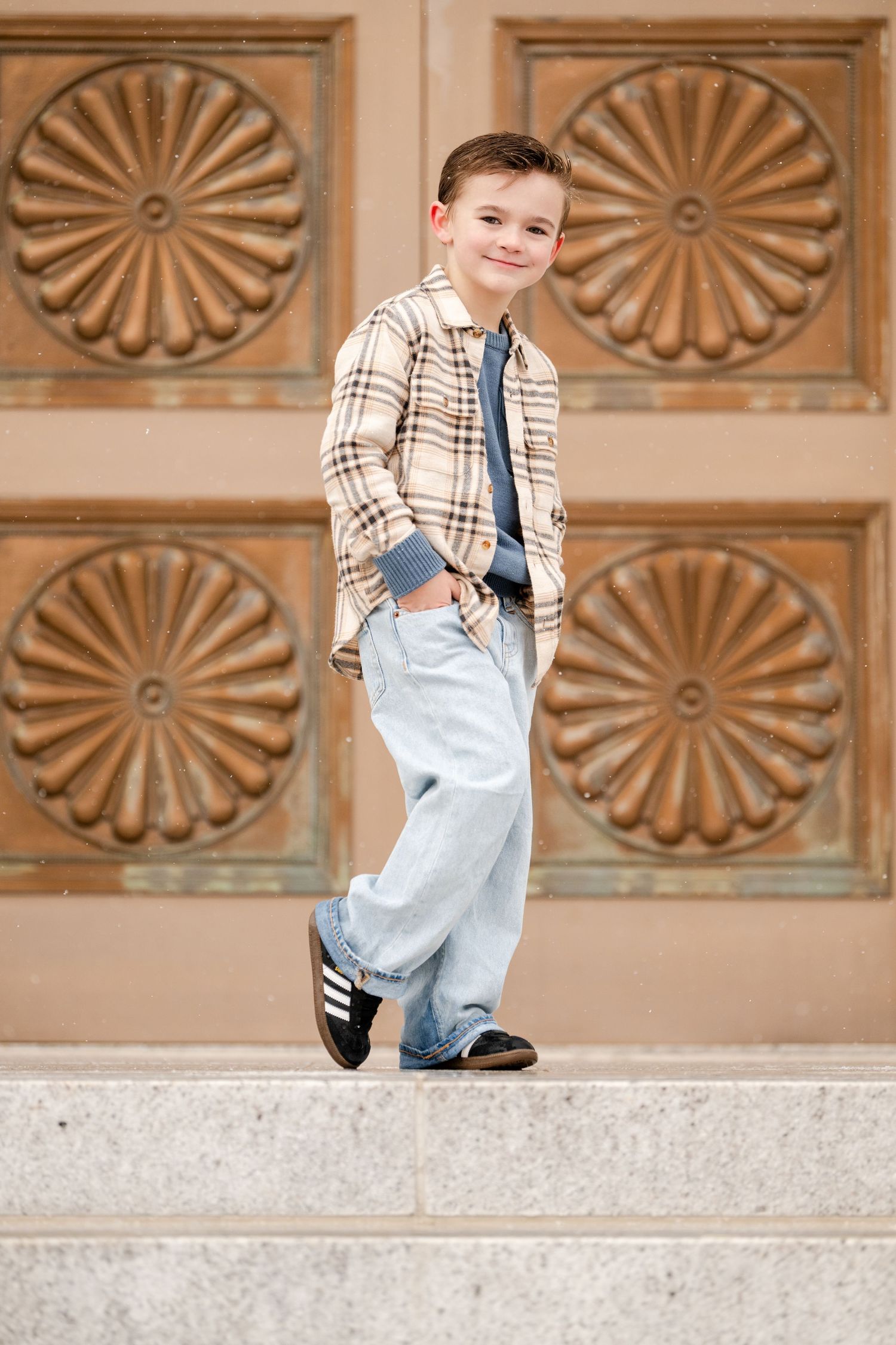 Smiling young boy portrait standing on outdoor steps during family photography session