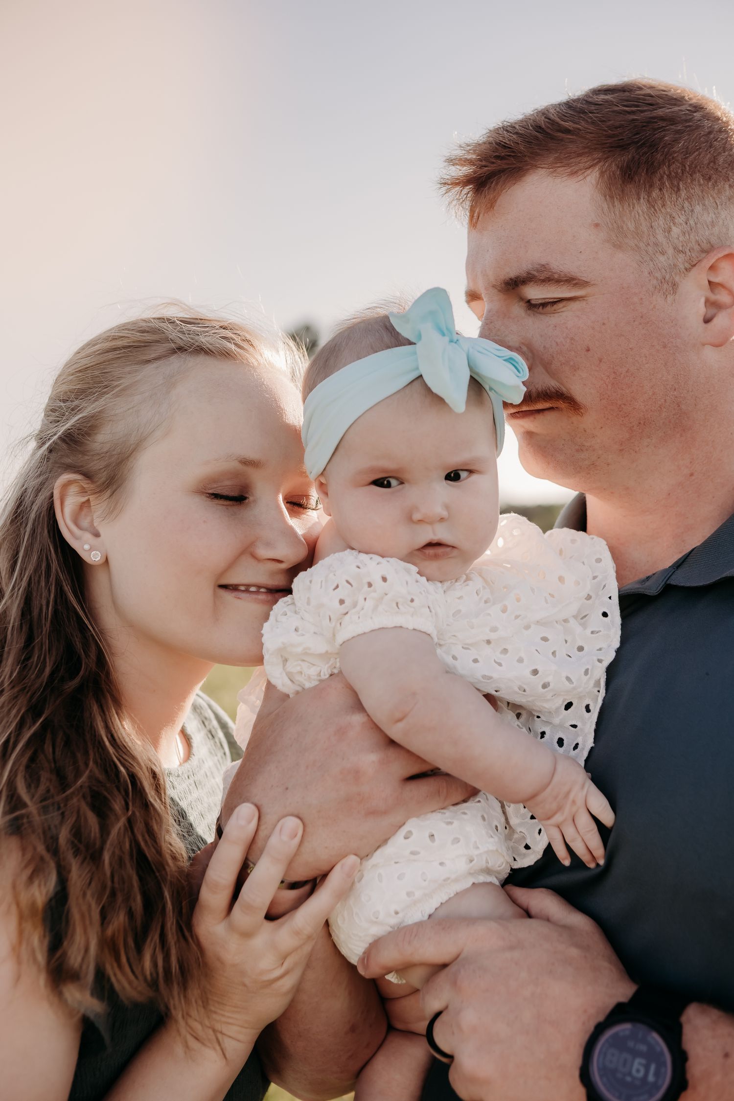 Family photo series showing tender moments between parents and baby in natural light.