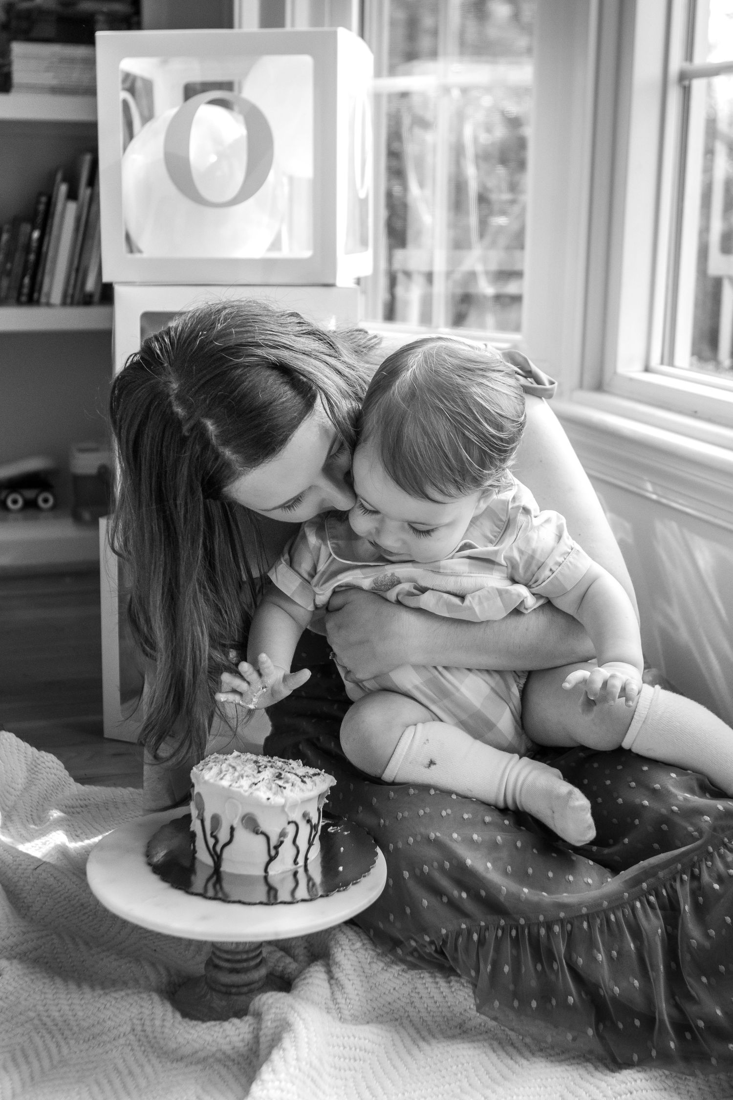 A series of four sequential images showing a playful interaction with a birthday cake face-planting scene in black and white.