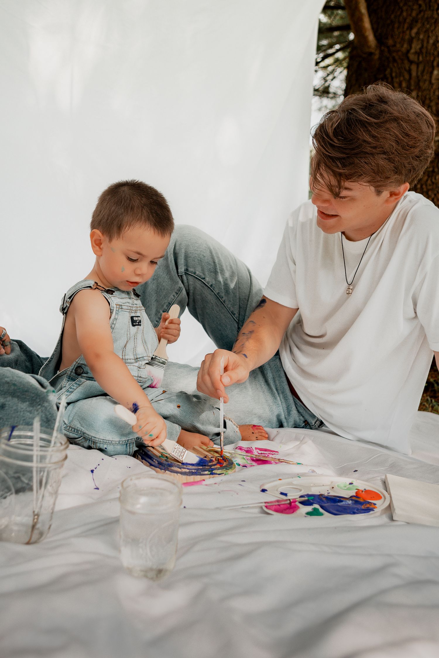 Creative painting session captured in sequence showing collaborative art-making on white surface.