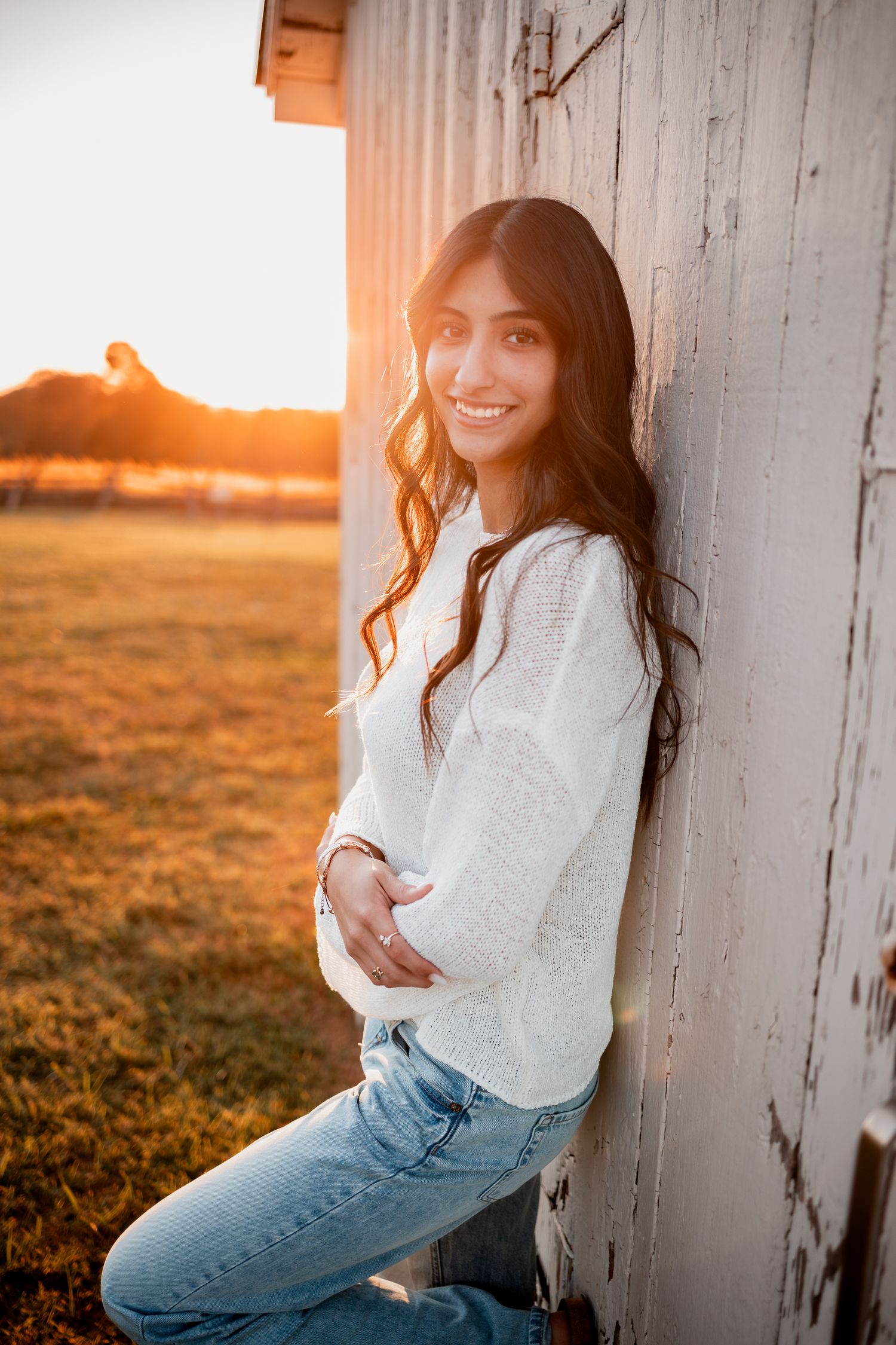 Portrait series against a white barn wall during sunset with warm golden lighting.