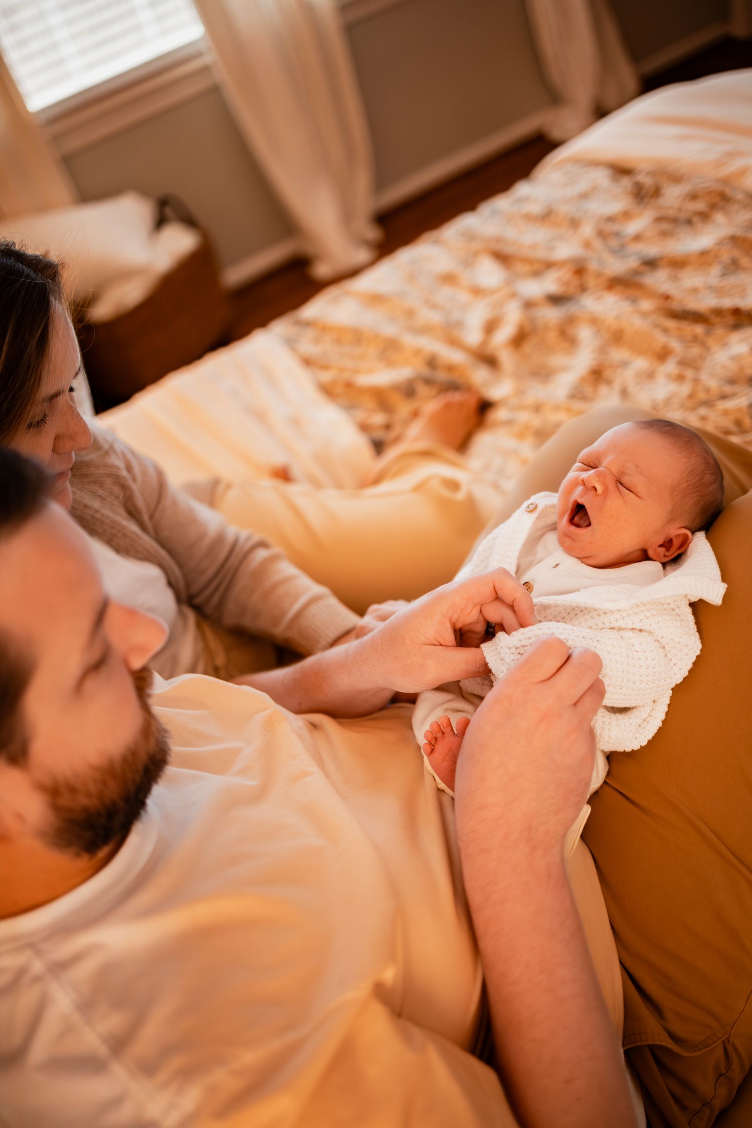 A tender parenting moment captured in warm lighting as they care for their baby.