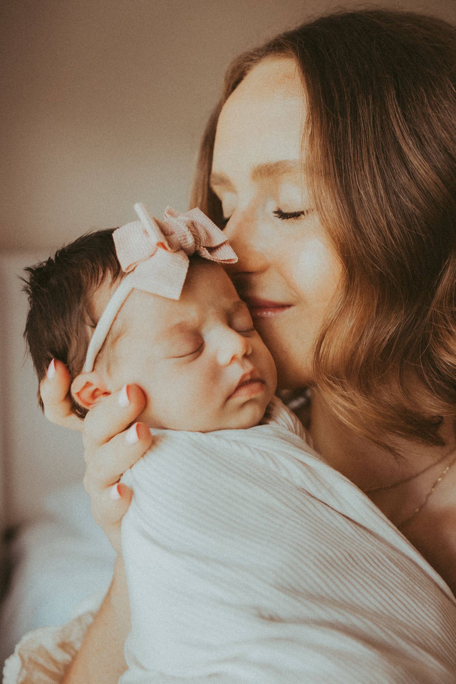 A tender moment of parent and baby sharing affectionate kisses in a series of warm-toned intimate photographs.