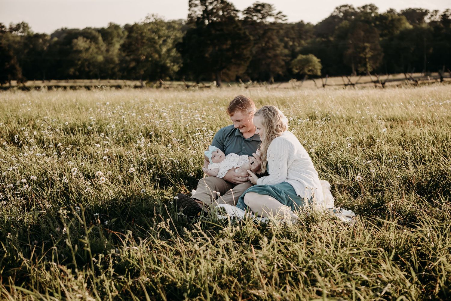 A couple sharing tender moments together in a sunlit meadow field during golden hour.