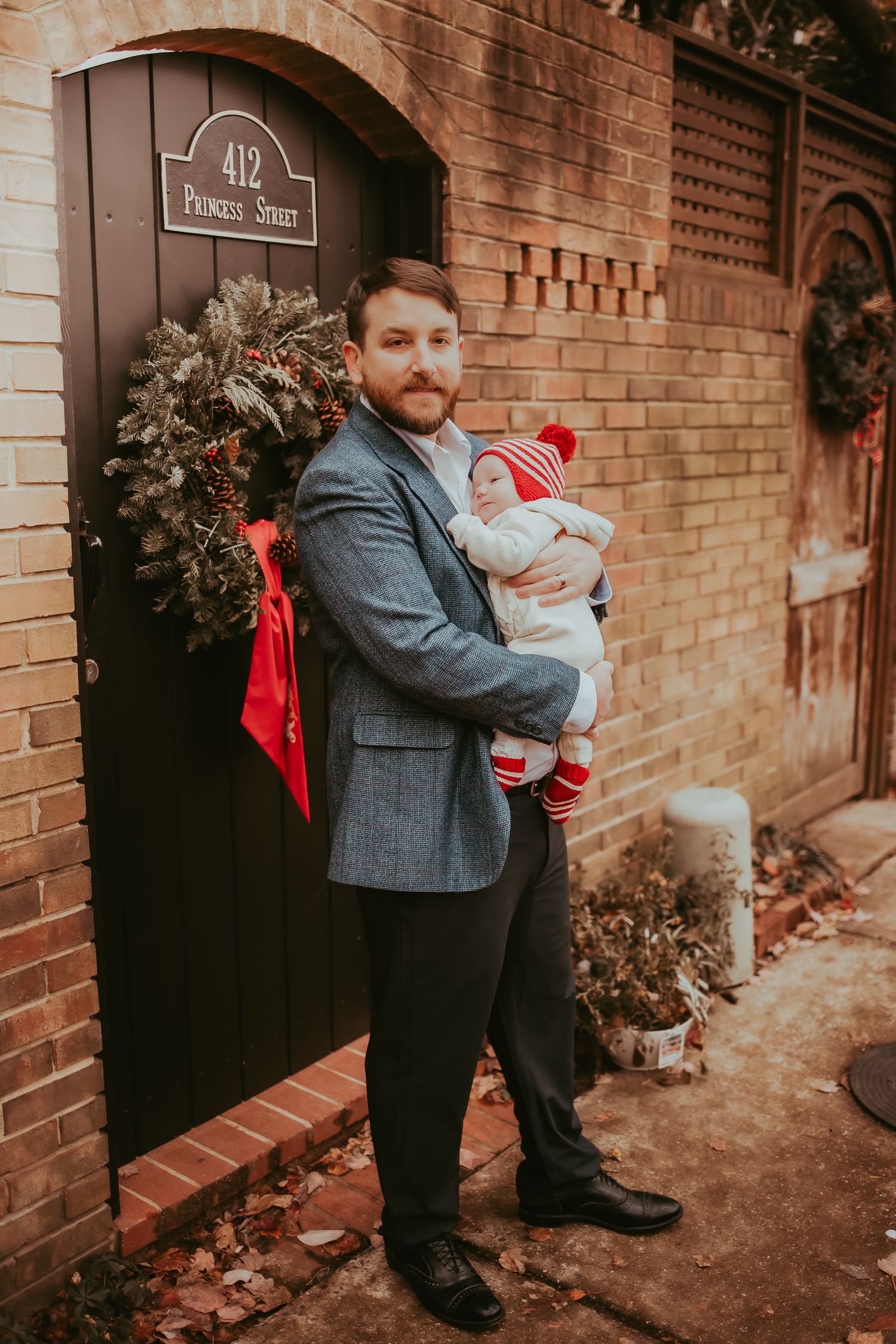 A series of outdoor portraits showing a person in a grey coat holding a small baby against a brick wall background.