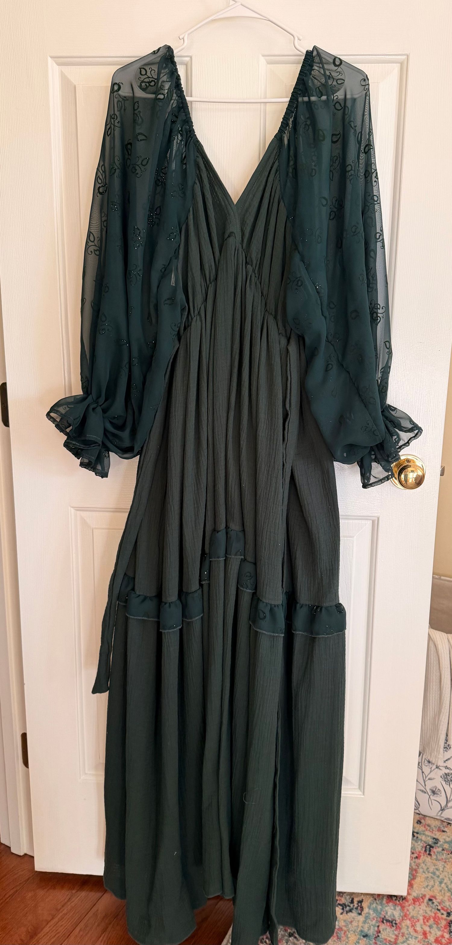 A dark green vintage-style dress with long sleeves and pockets hangs on a white door, shown from multiple angles.