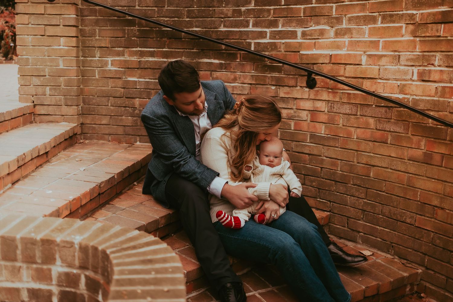 A series of intimate family moments captured against a rustic brick wall backdrop in warm lighting.