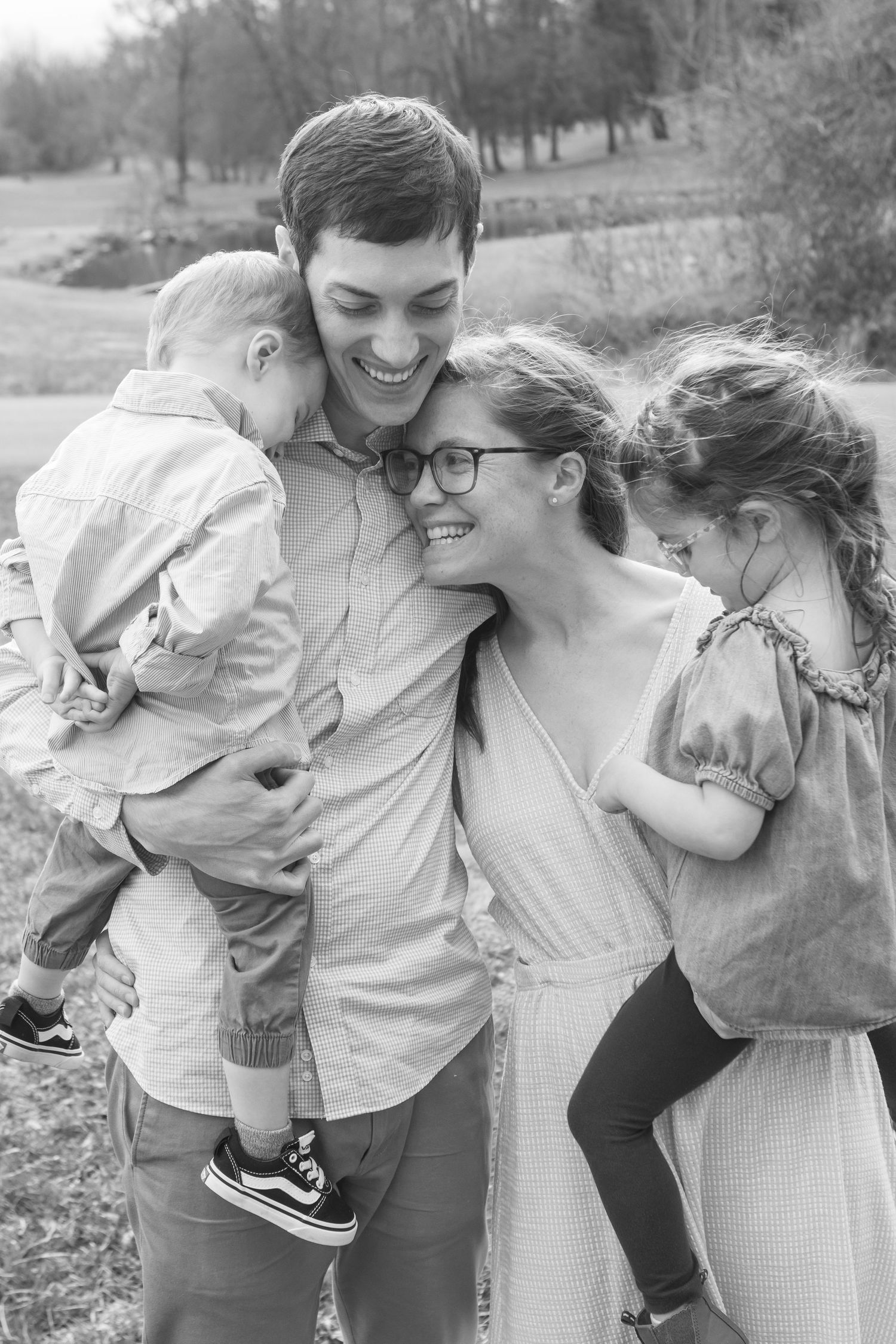 A joyful black and white candid family moment shared outdoors in a natural setting.