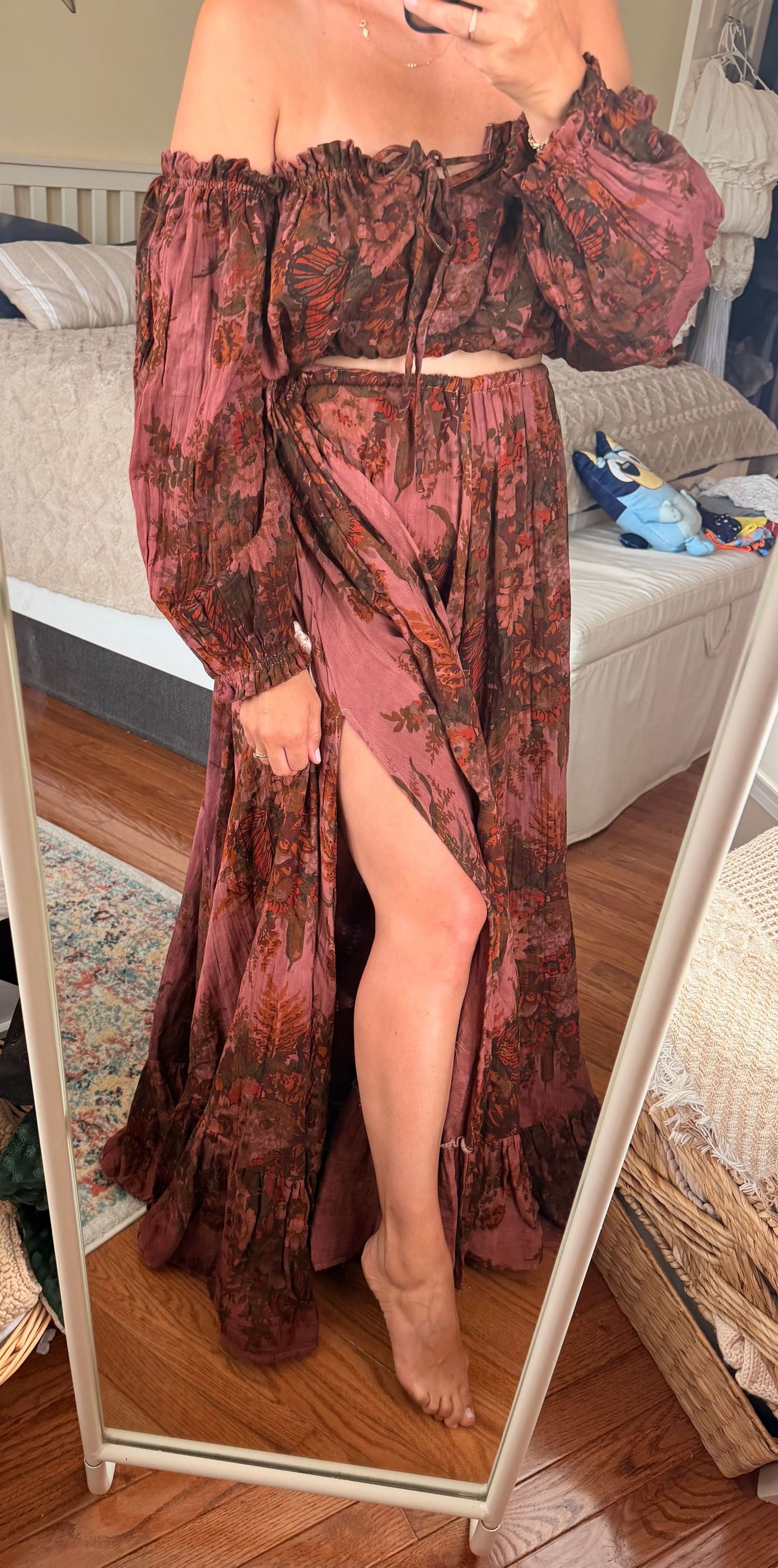 Woman wearing a boho floral mauve two-piece set with off-shoulder crop top and high-slit maxi skirt.