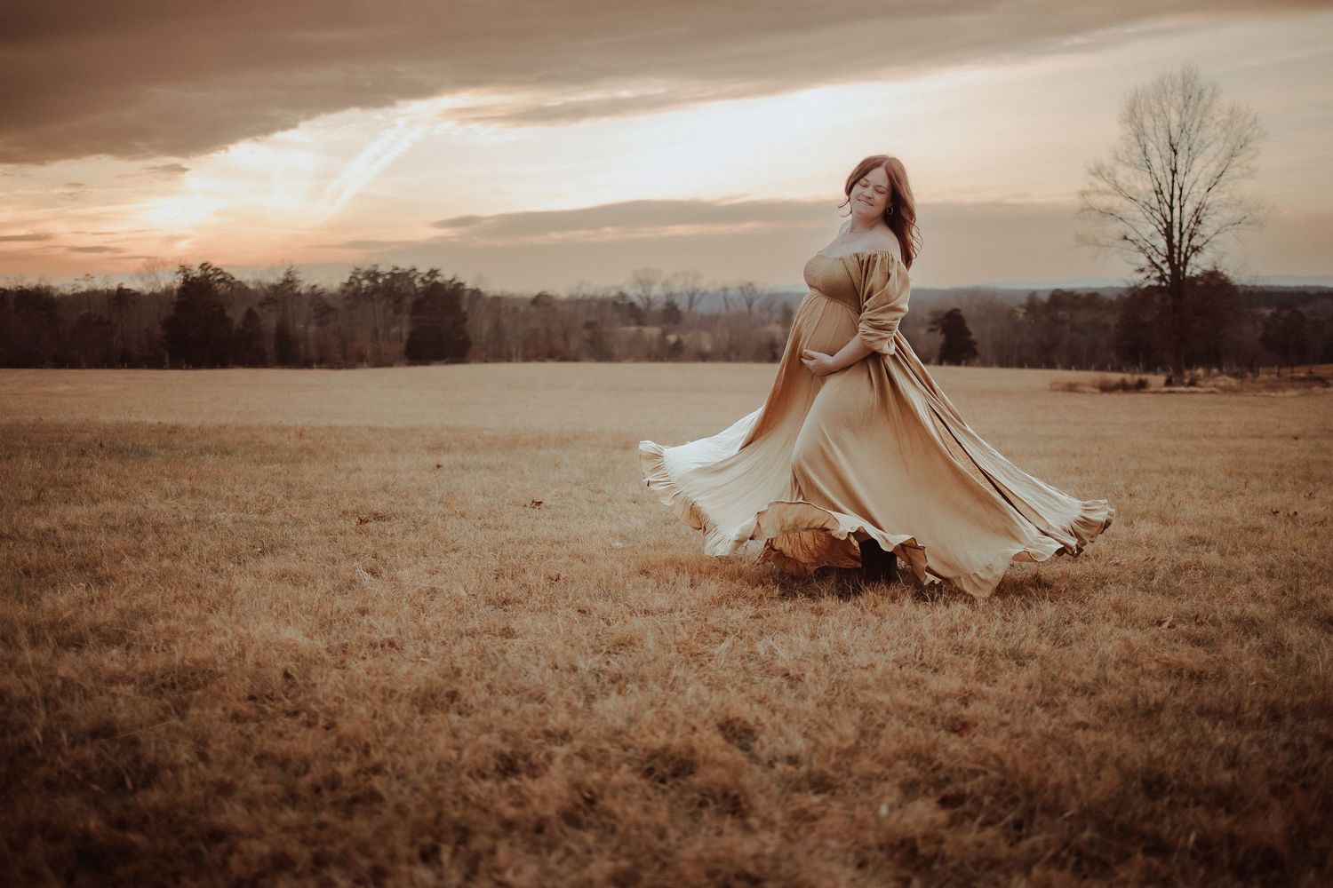 A person in a flowing white dress twirls gracefully across a serene autumn field at sunset.