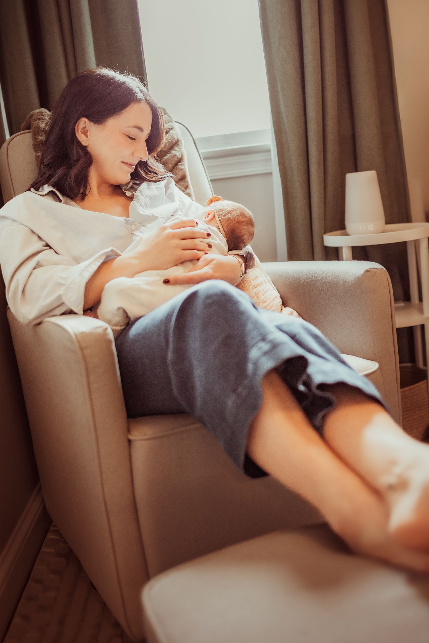 A person wearing white lounges comfortably on a gray couch in a series of relaxed poses.