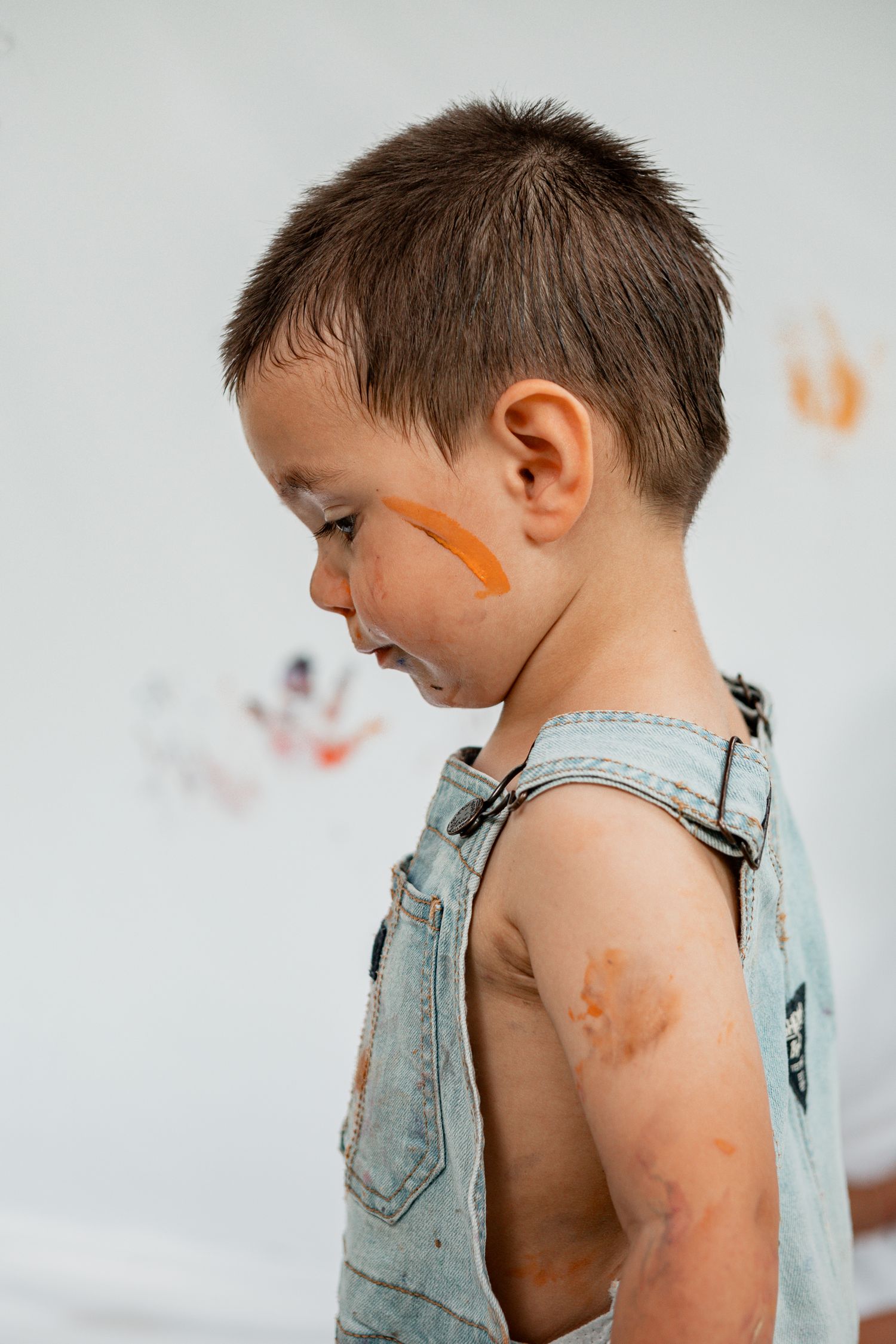 Side view of paint stains on a denim overalls silhouette with light background in photography sequence.