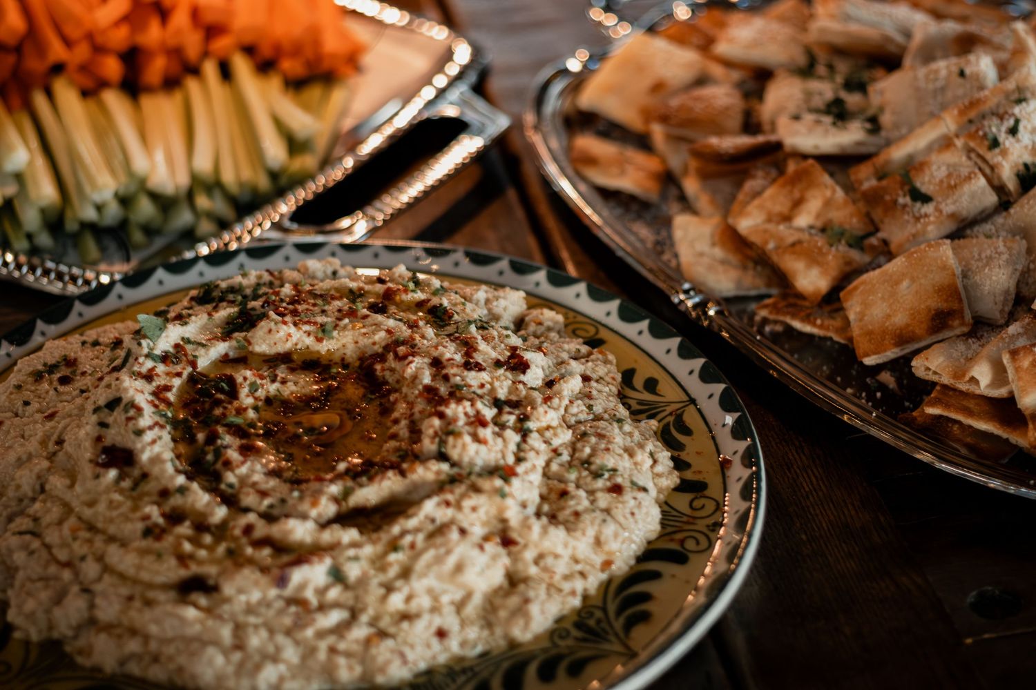 Various Italian dishes served buffet-style including pasta, risotto and chicken dishes arranged on elegant silver platters.