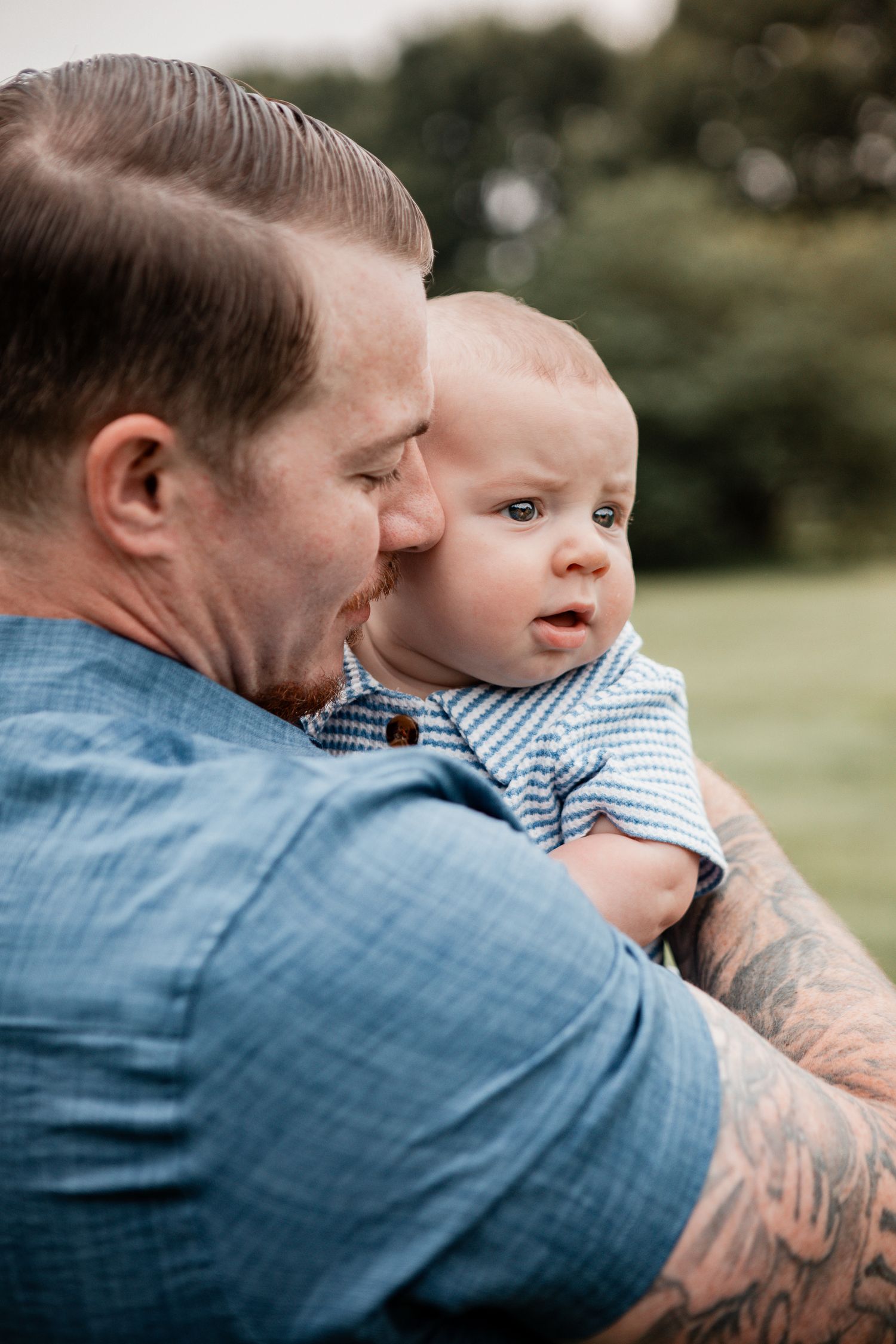 Candid outdoor sequence shows affectionate moments between adult and baby in blue denim shirt.