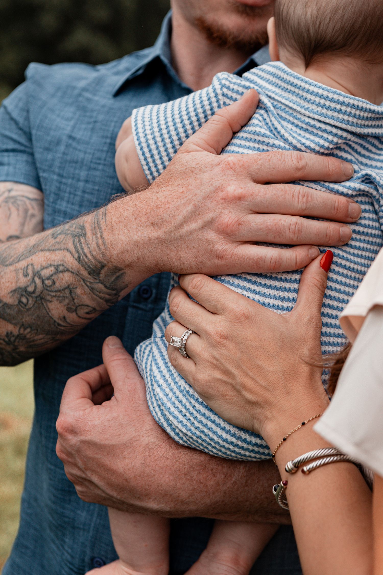 Close-up sequence of tattooed hands gently holding and caressing in blue striped fabric.