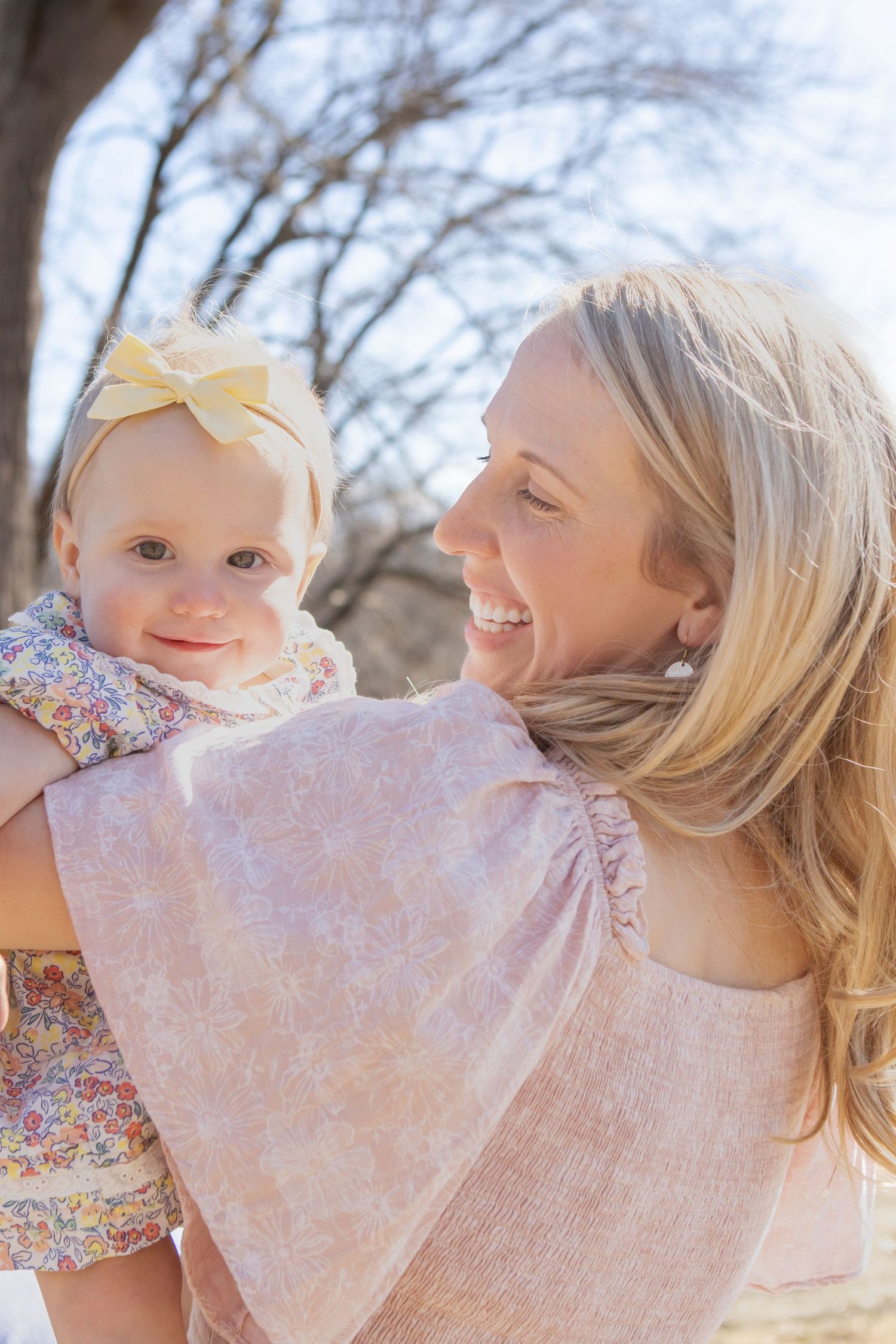 A sunny outdoor portrait showing joy and connection between parent and child.