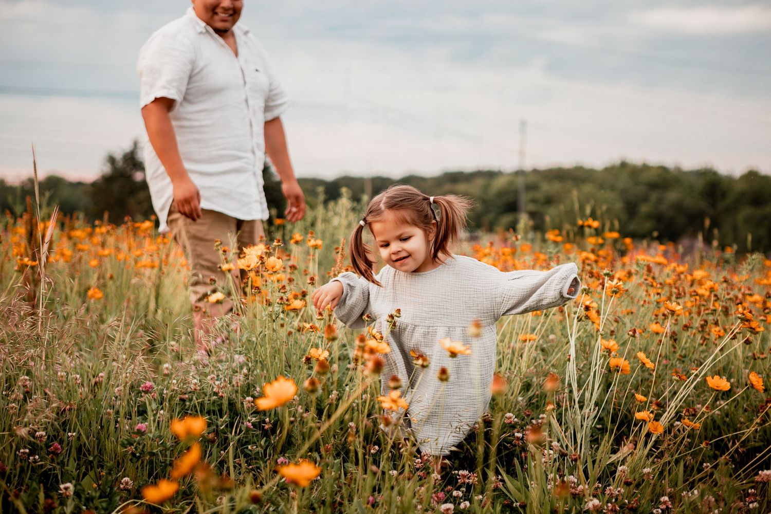 A picture series showing a family enjoying time together in a vibrant orange wildflower field at sunset.