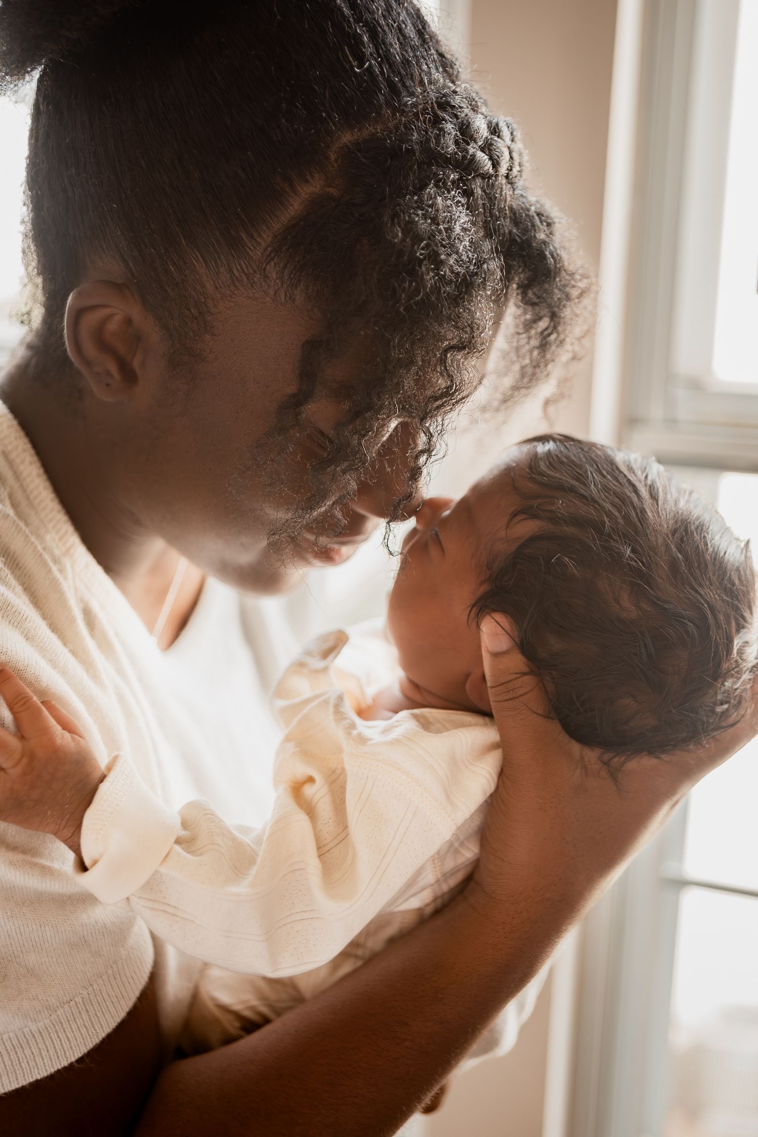 Series of warm-toned photos showing a tender embrace between two figures in soft natural light.