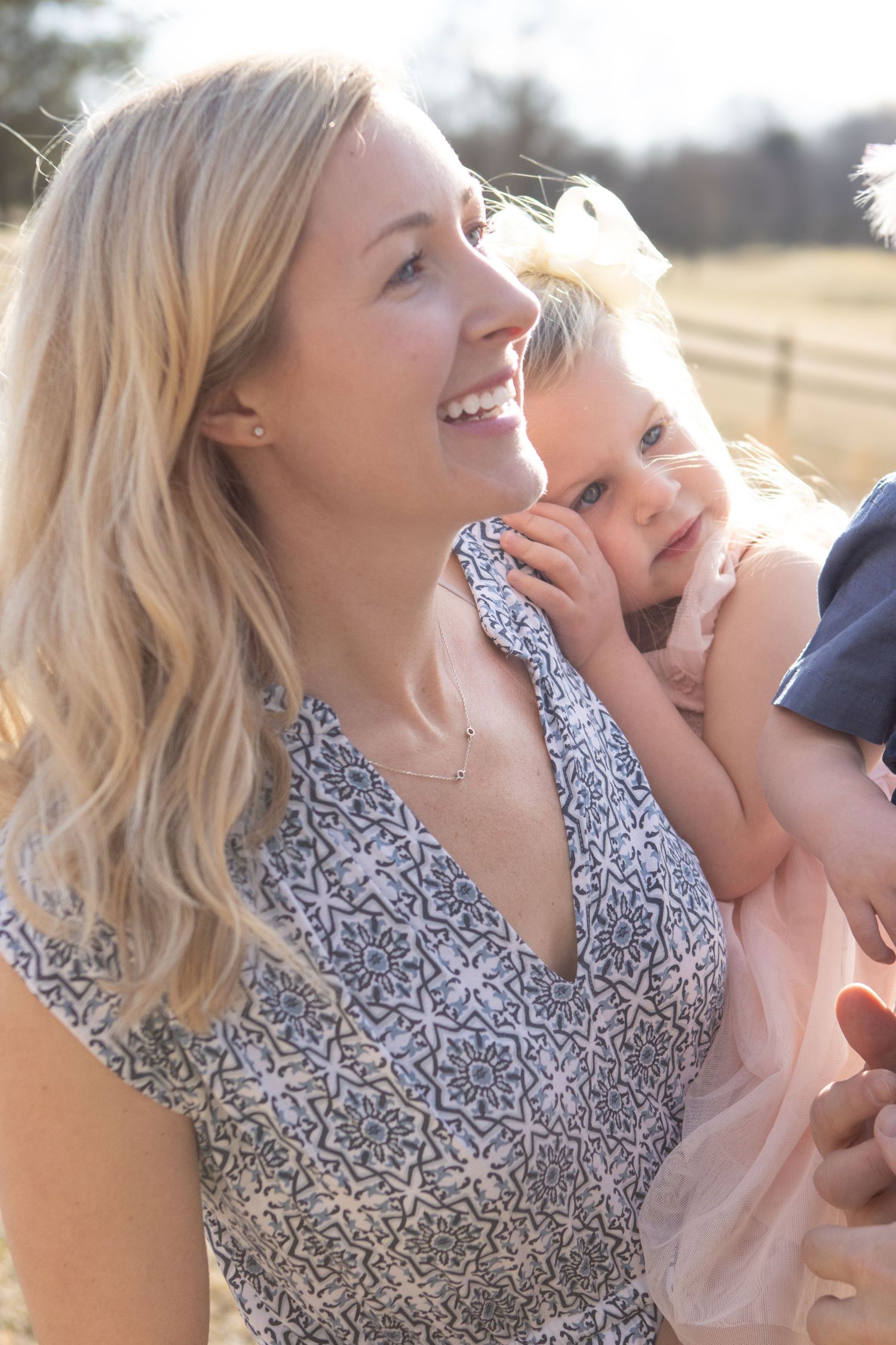 A sunny outdoor portrait showing shared laughter and closeness.