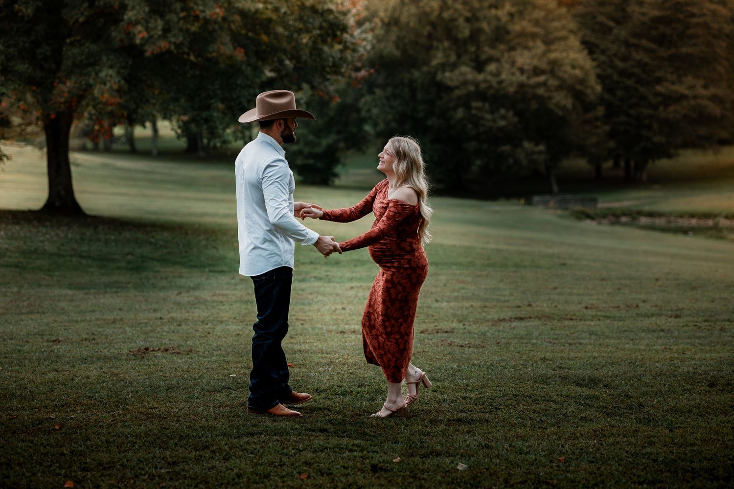 Silhouettes dance together on a scenic grassy hill during golden hour.