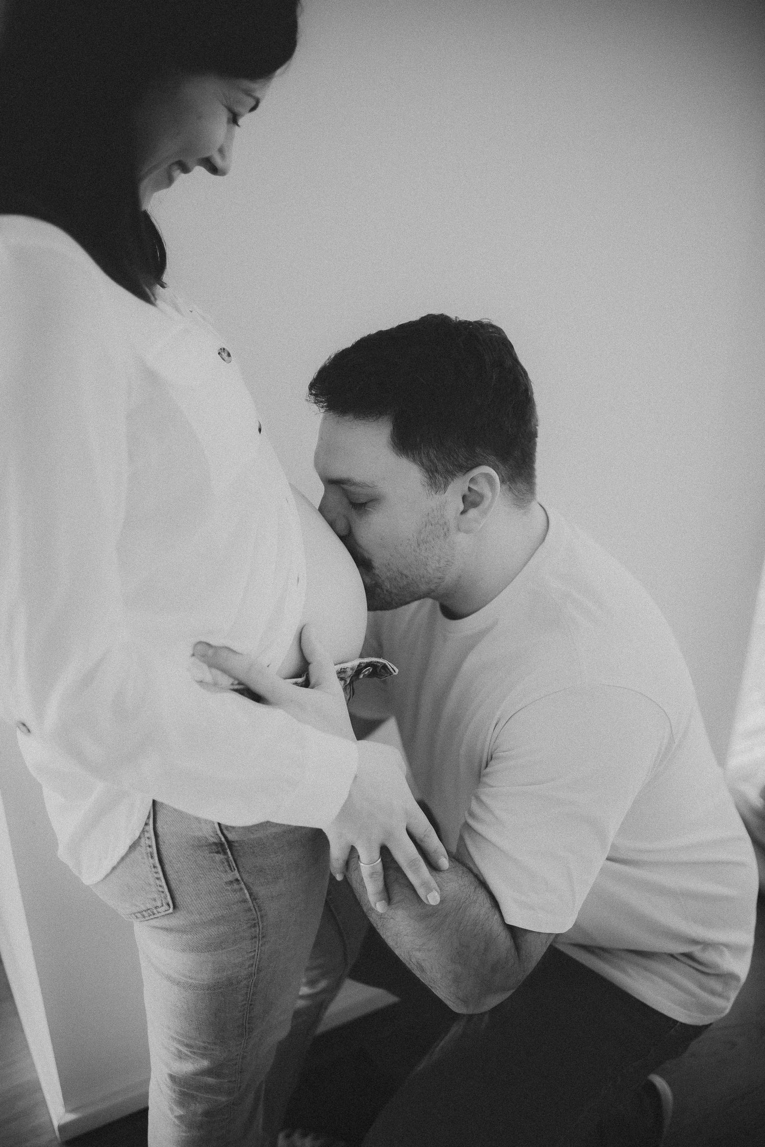 Black and white intimate maternity photo showing tender moments between expectant parents.