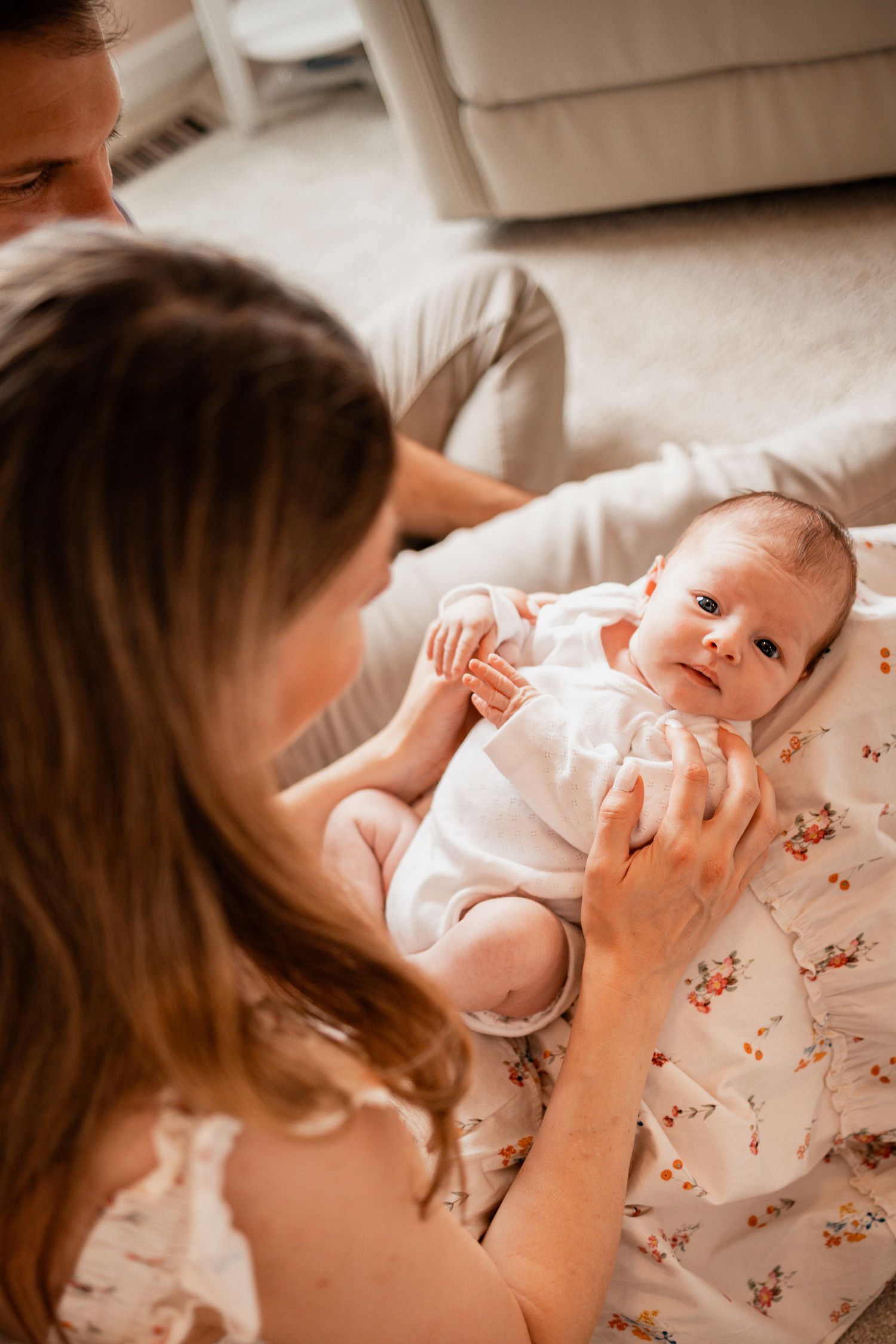 A tender series of photos showing a parent bonding with their infant in a soft, natural light setting.