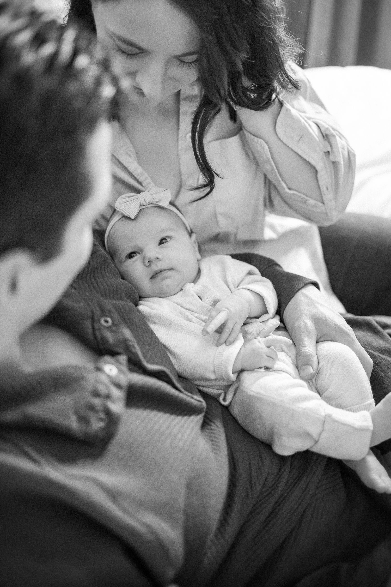 An intimate black and white photograph capturing a quiet family moment on a couch.