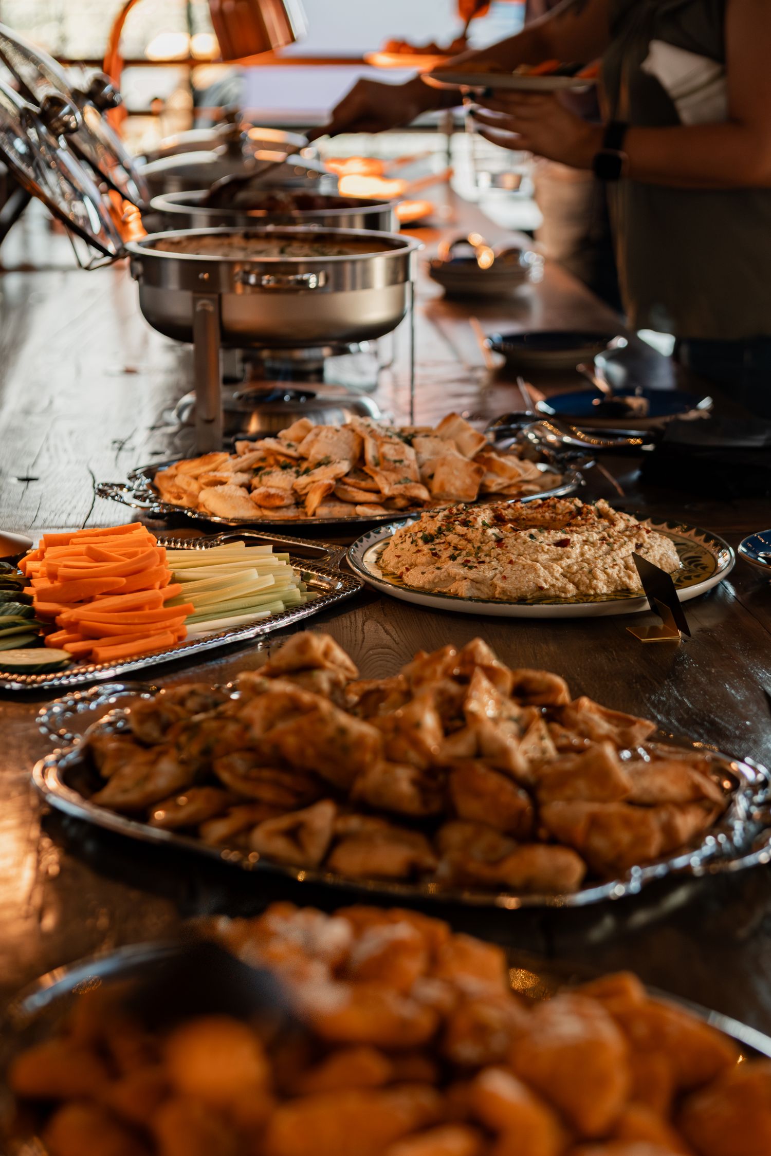 An array of appetizers and finger foods displayed on platters at a catered event.