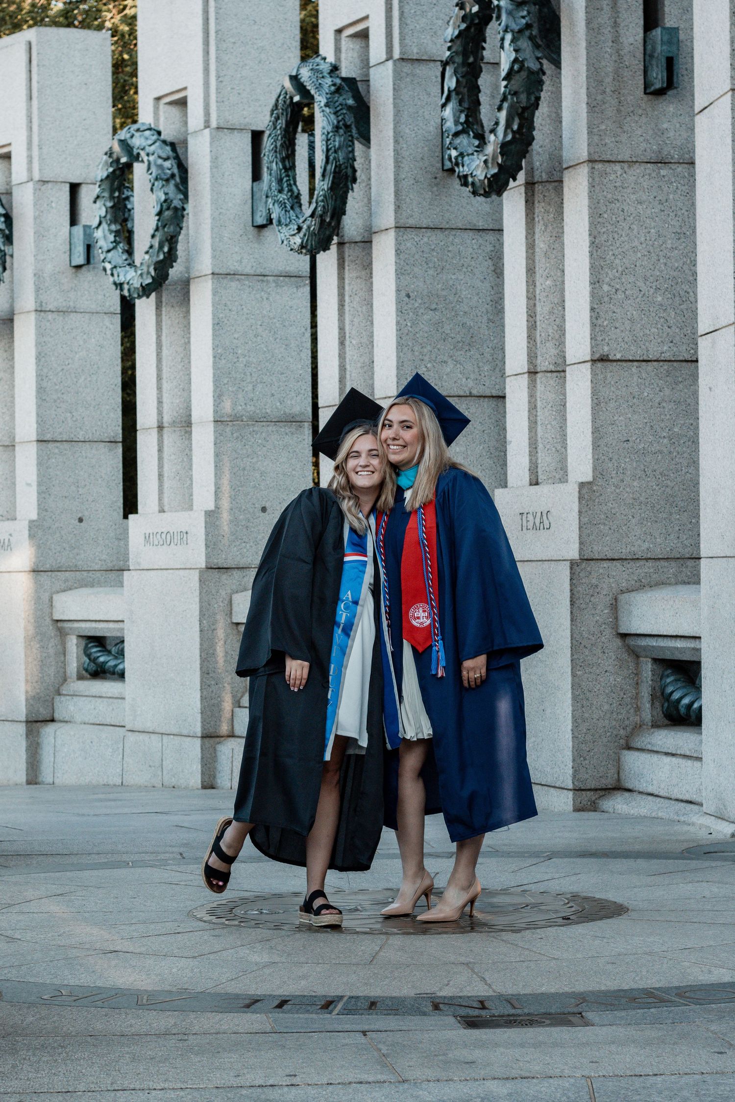 Graduation photos taken under white stone columns with graduates in blue gowns and red accents.