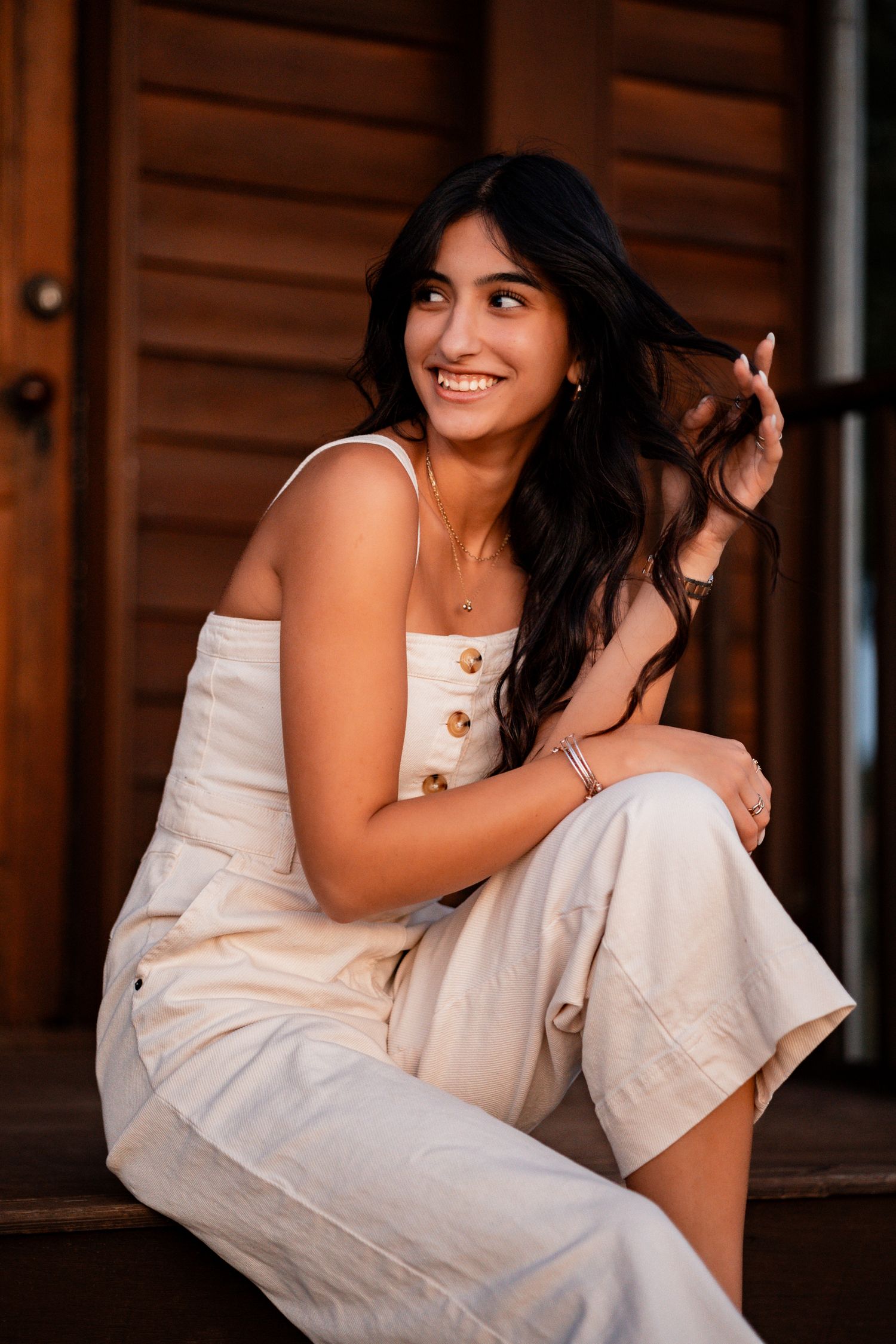 Lifestyle portraits against wooden paneling showing a casual summer outfit and relaxed poses.
